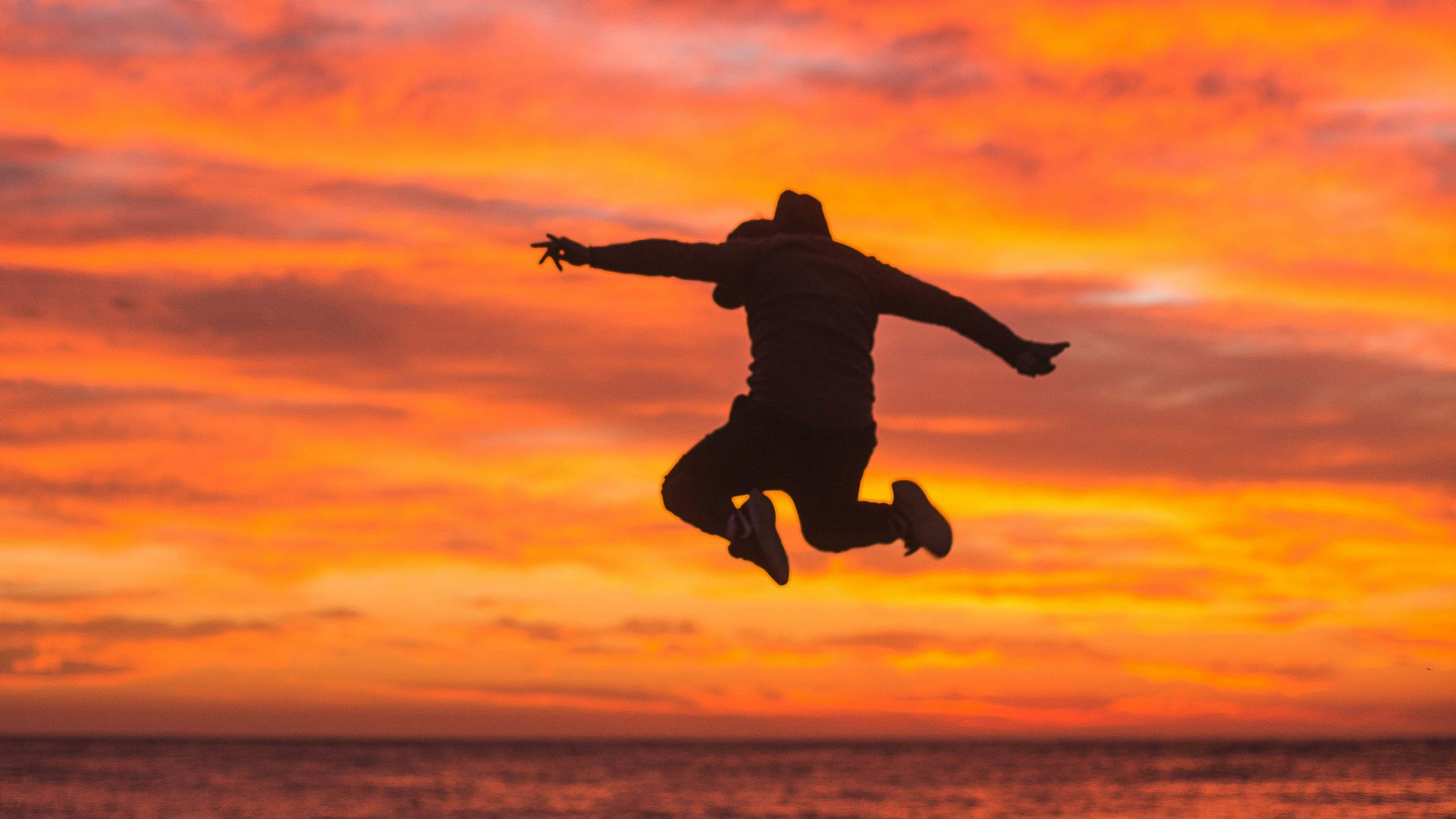 silhouette of person jumping above ground