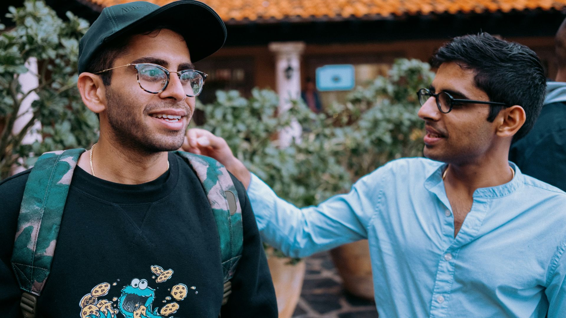 man in black crew neck shirt wearing black framed eyeglasses and black hat