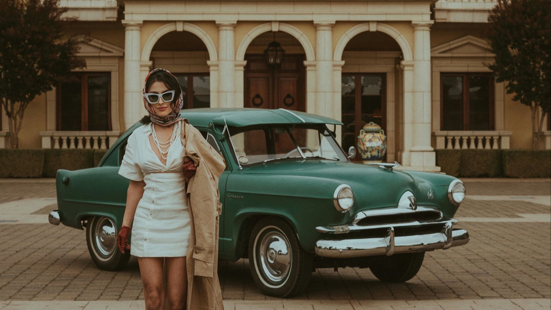 a woman standing in front of a green car