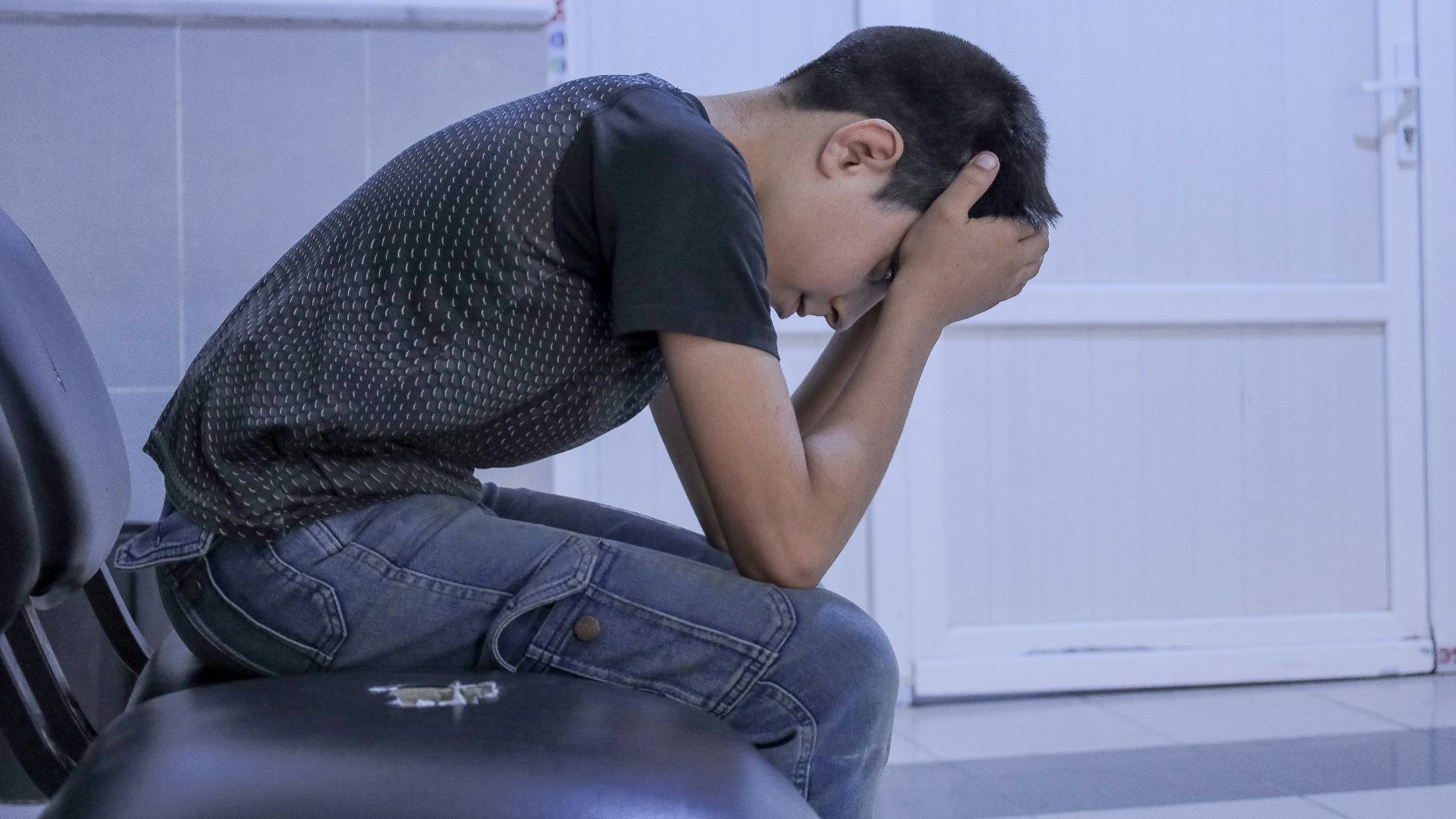 A man sitting on a chair with his head in his hands