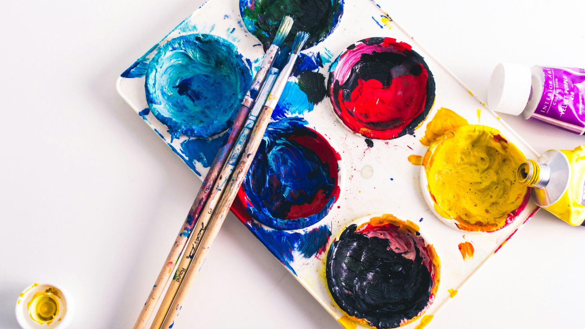 brown paint brushes on assorted-color paint palette