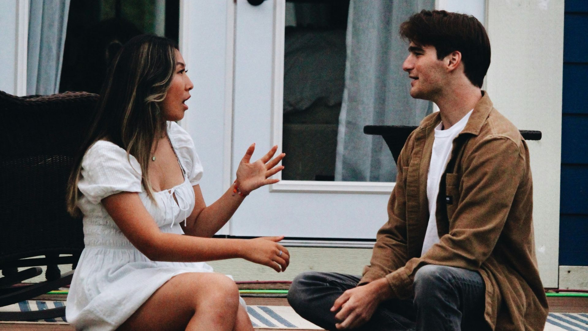 a man and woman sitting on a porch
