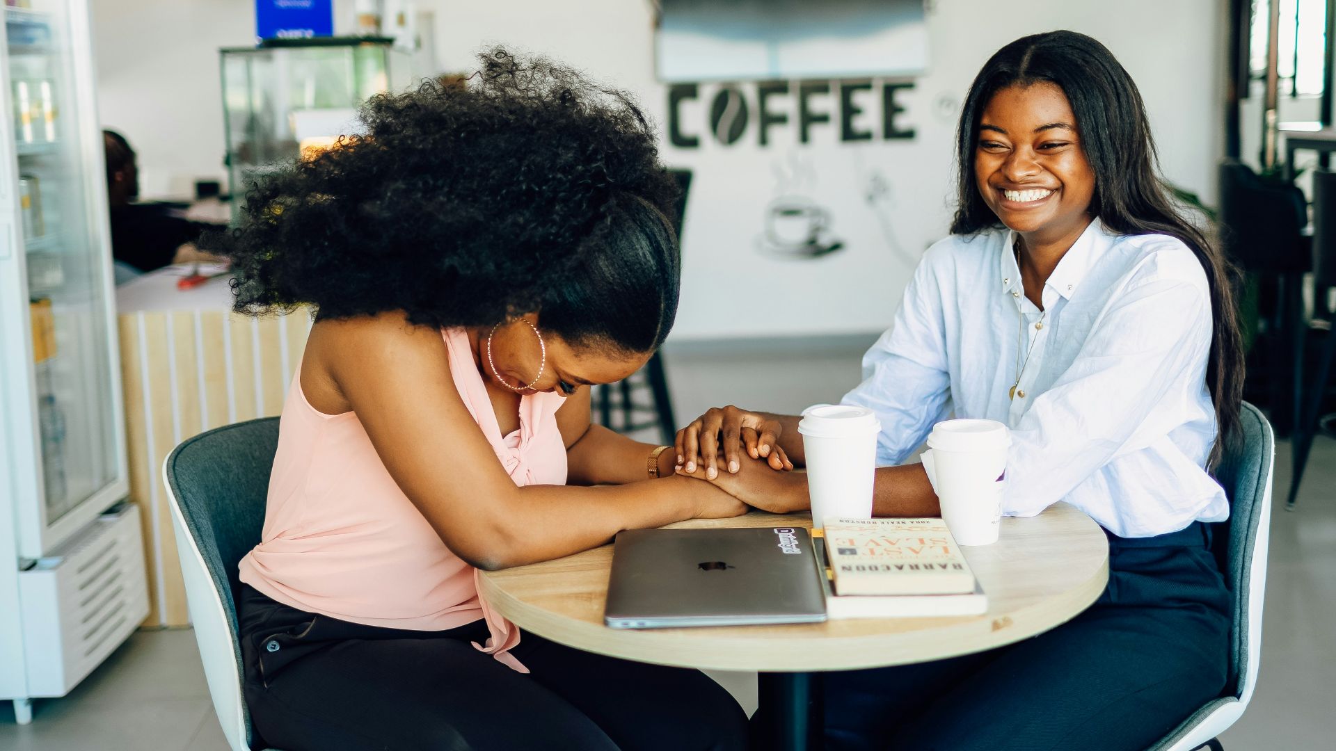 Two women sitting at a table working on a laptop