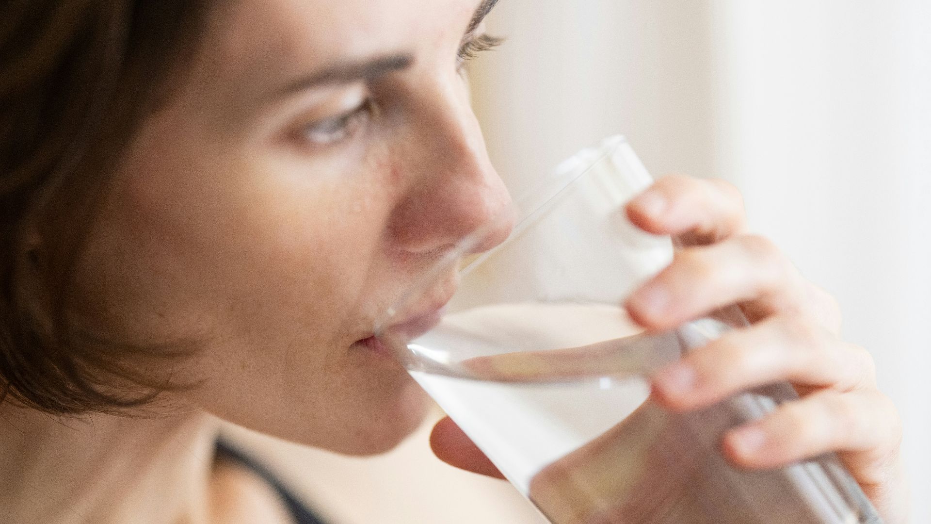 woman in black tank top drinking water