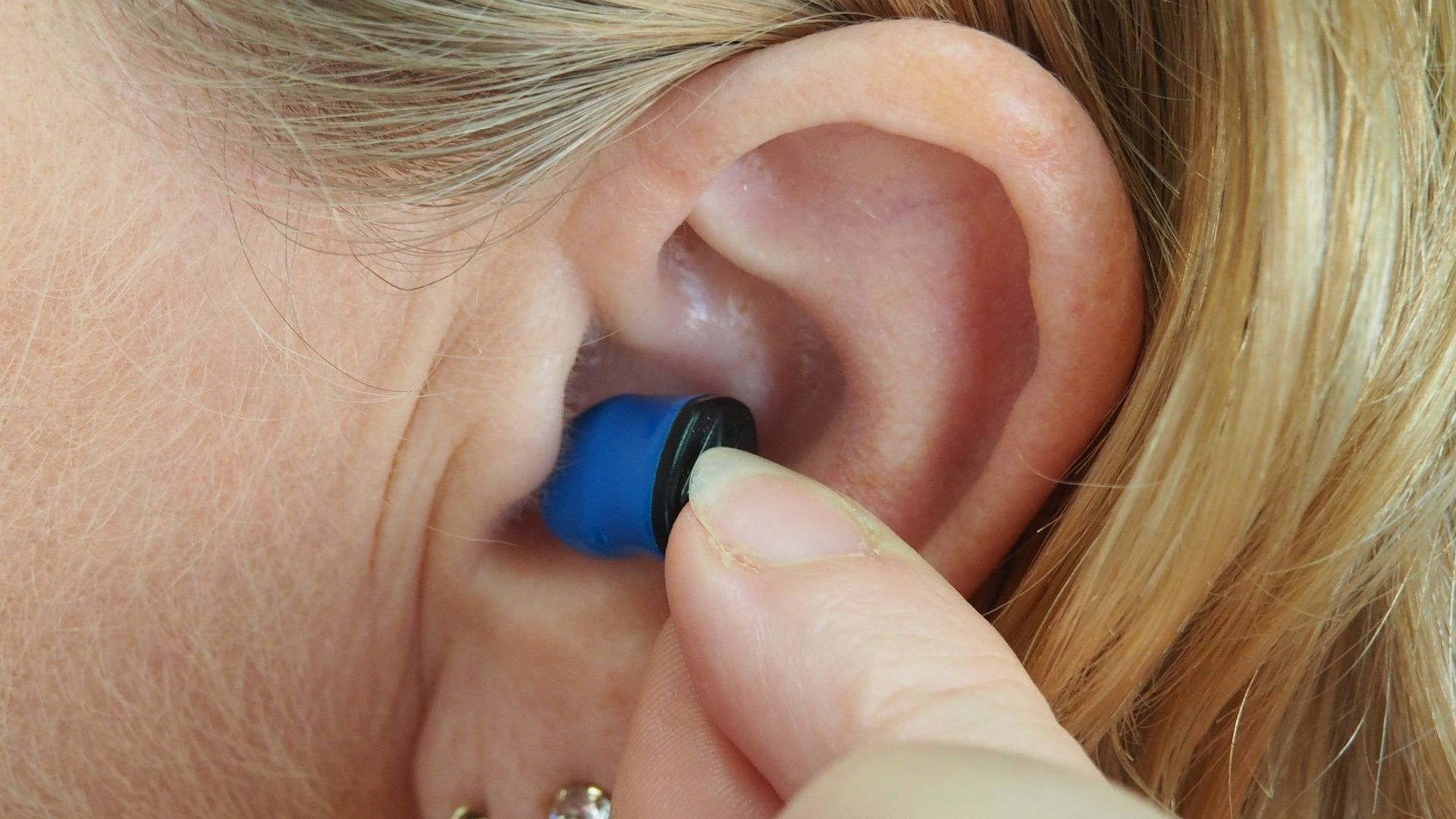 woman wearing blue stud earring