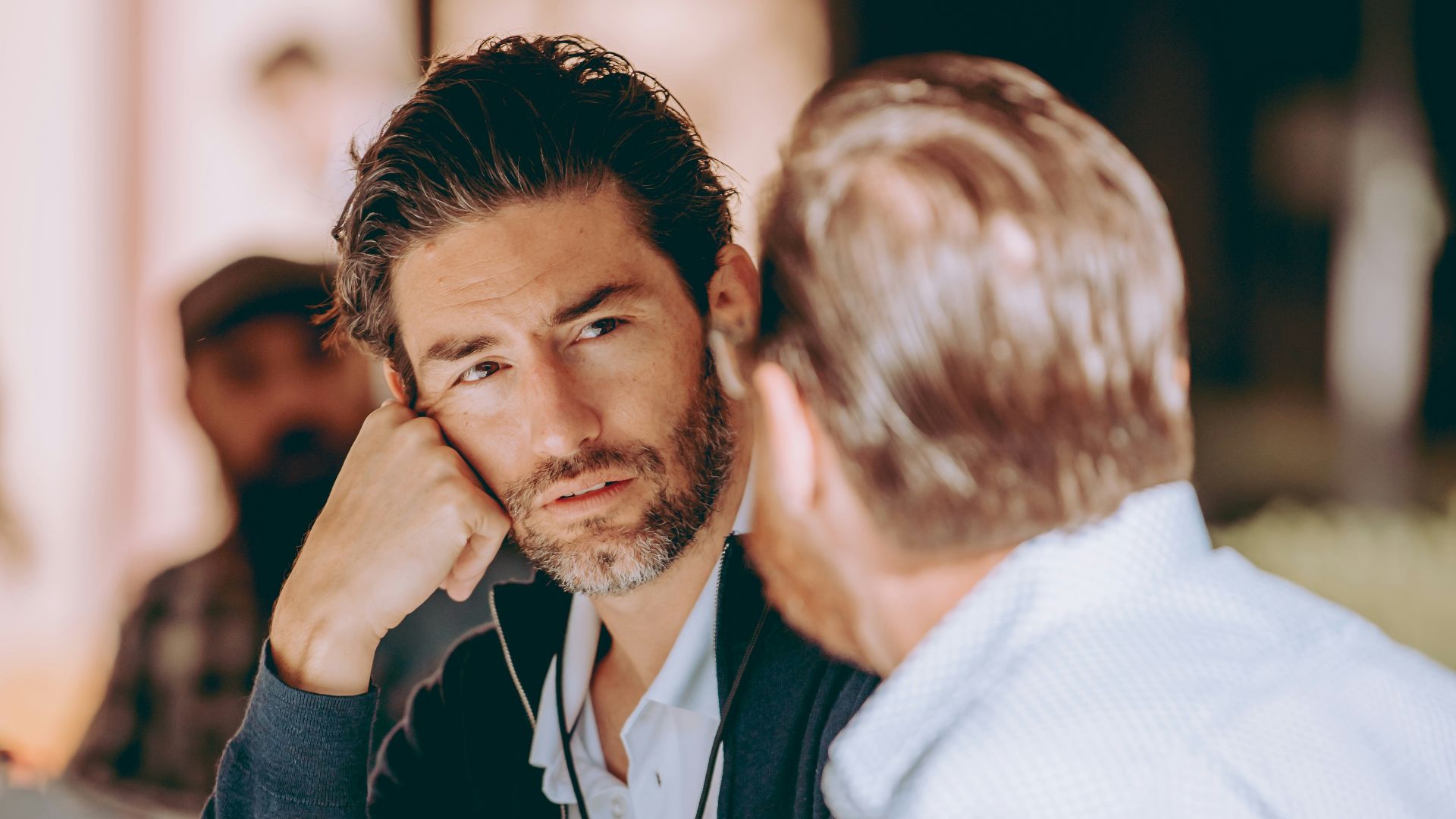 two men sitting at a table talking to each other