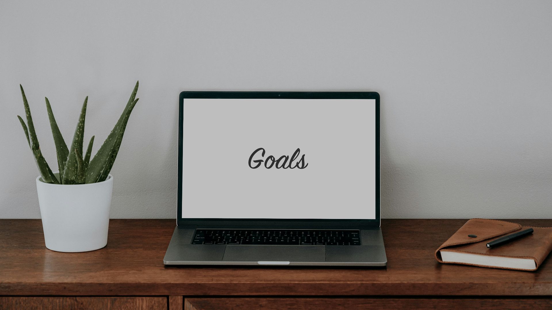 a laptop computer sitting on top of a wooden desk