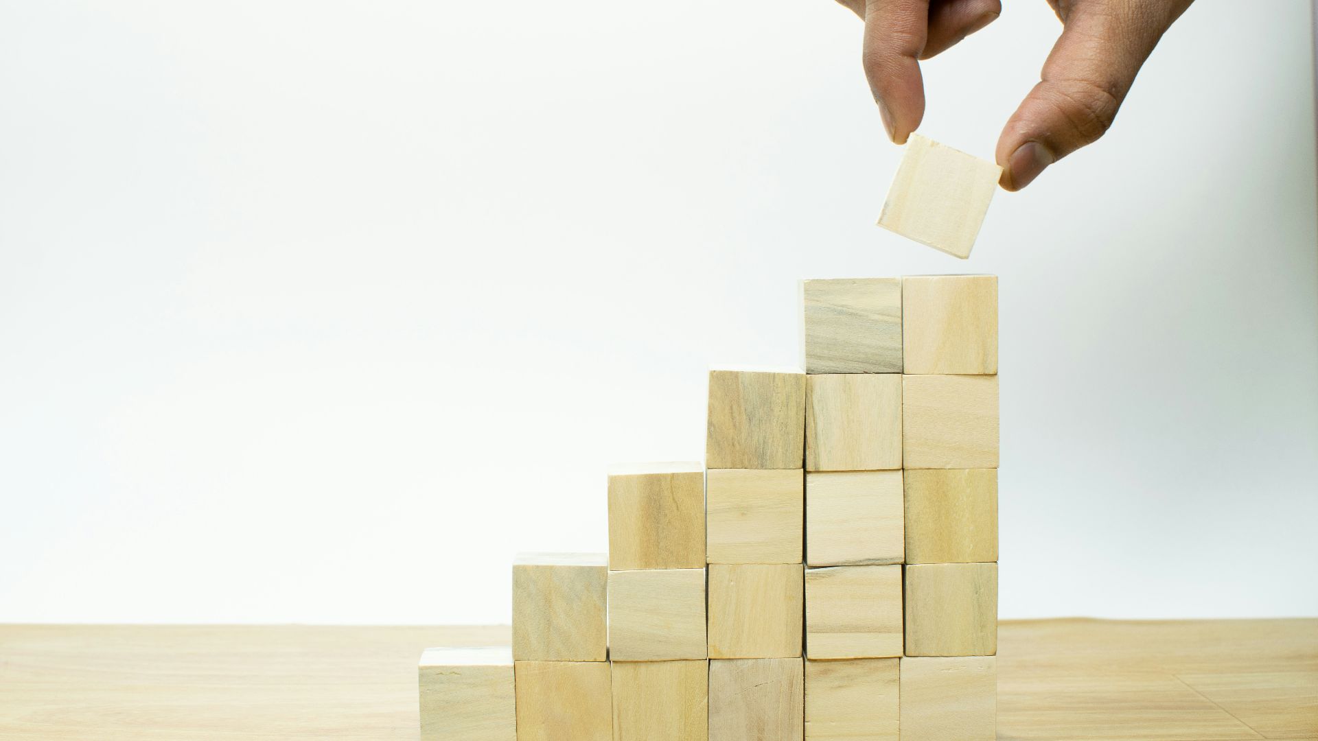 A person placing a piece of wood into a pyramid