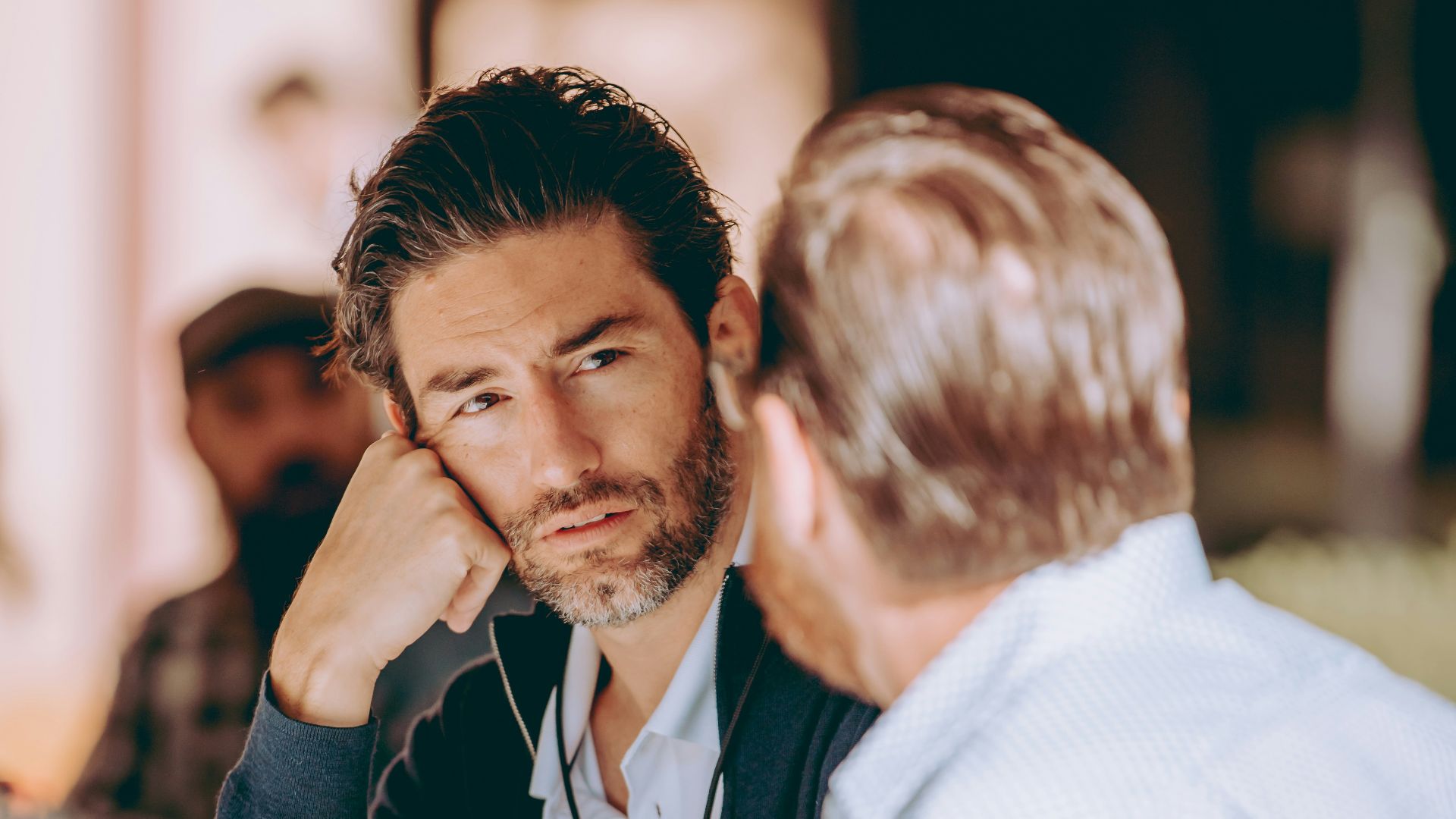 two men sitting at a table talking to each other