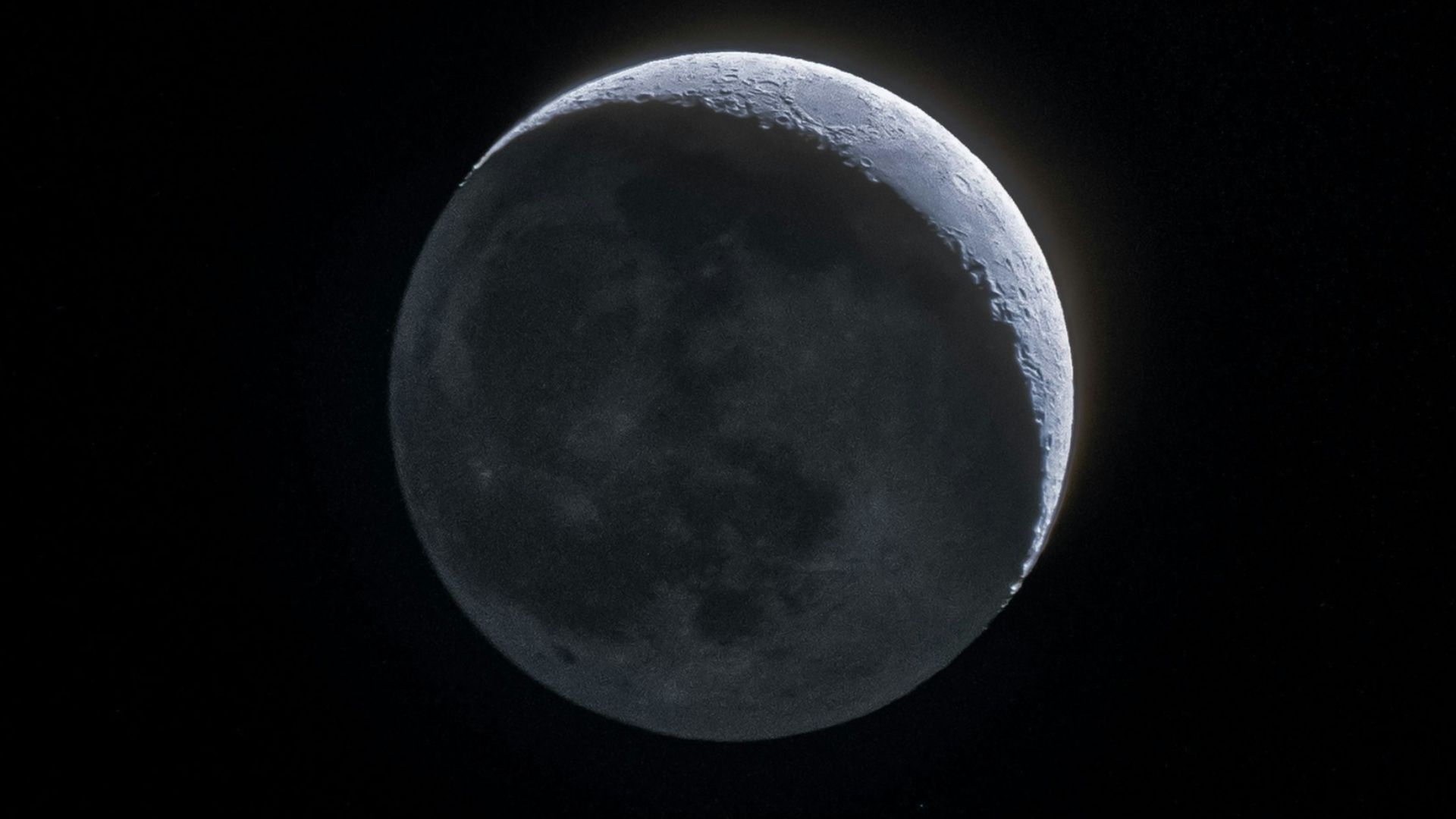 the moon is seen in the dark sky