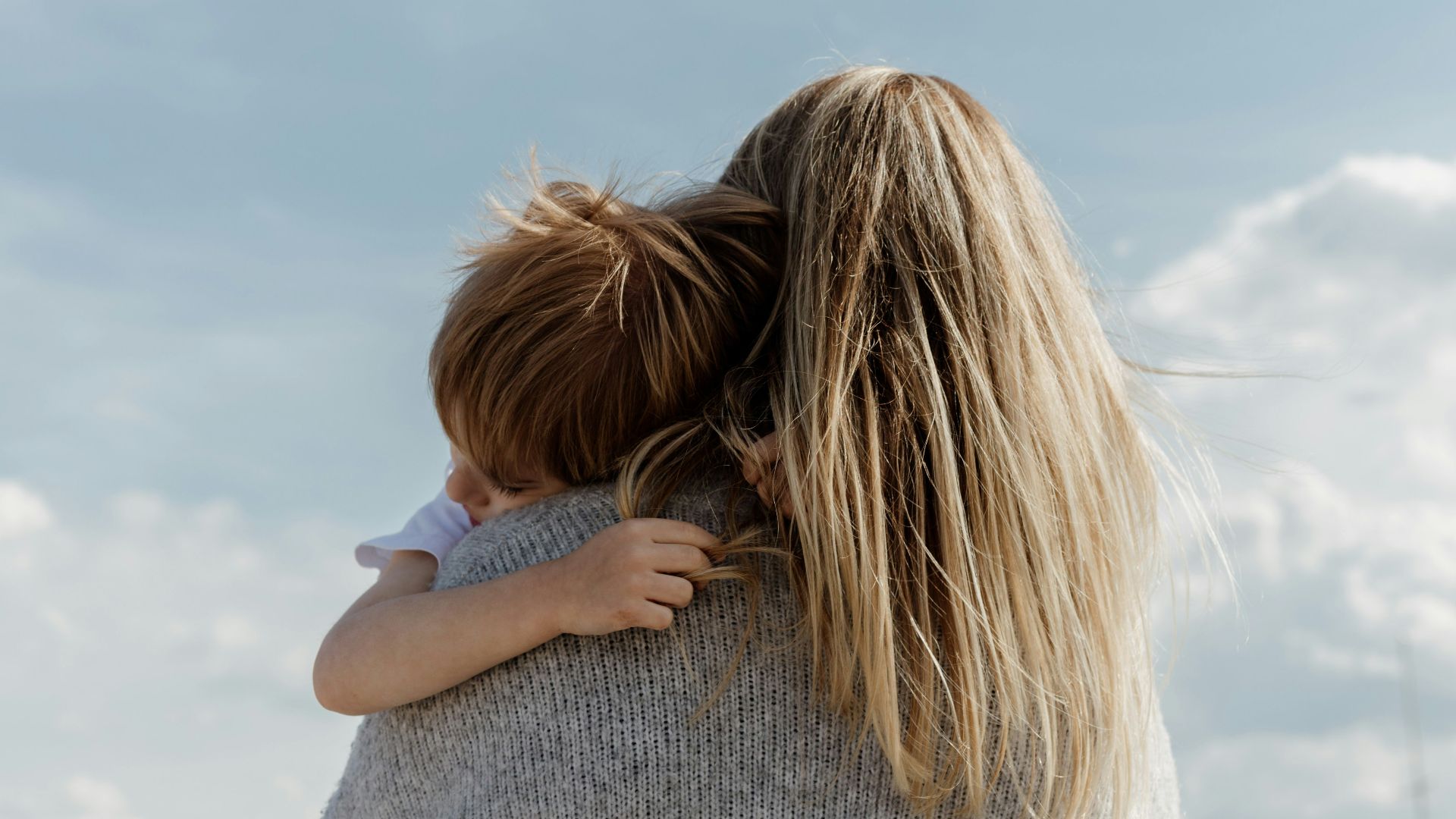 woman in gray shirt covering her face with her hair