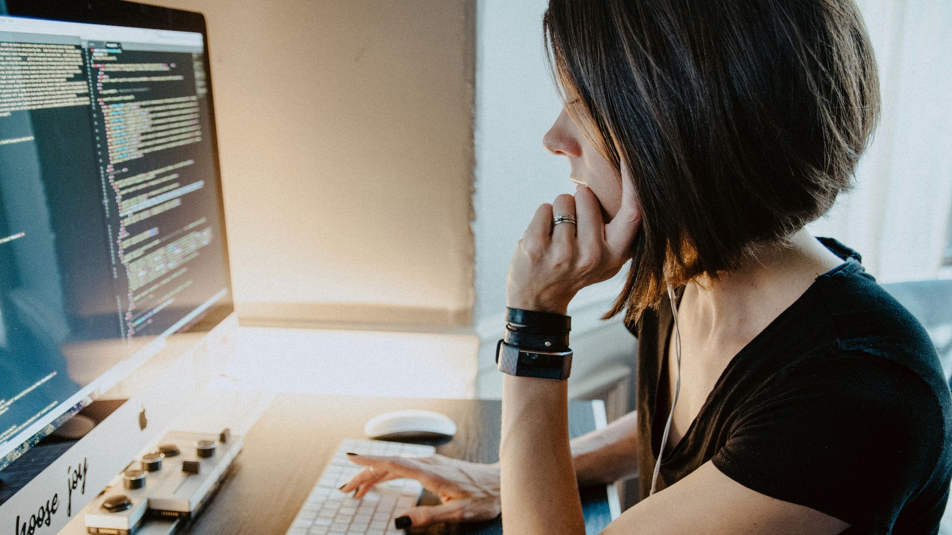 woman wearing black t-shirt holding white computer keyboard