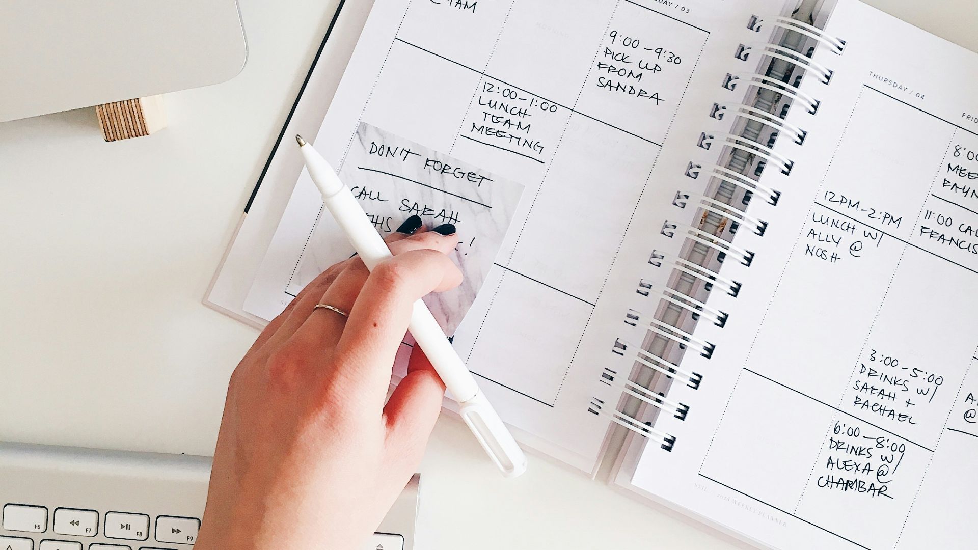 person holding notepad and pen flat lay photography