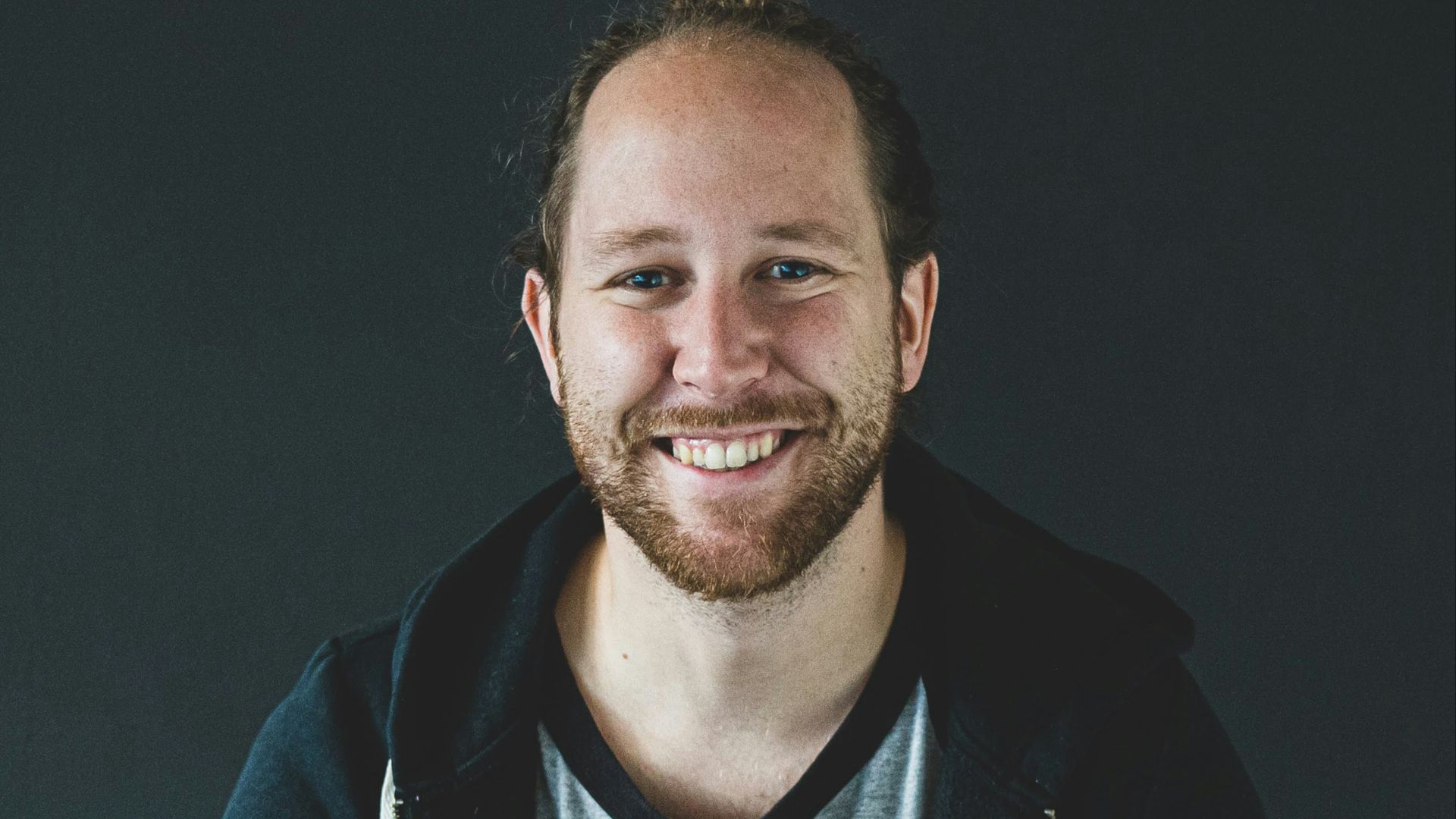 man in black jacket smiling