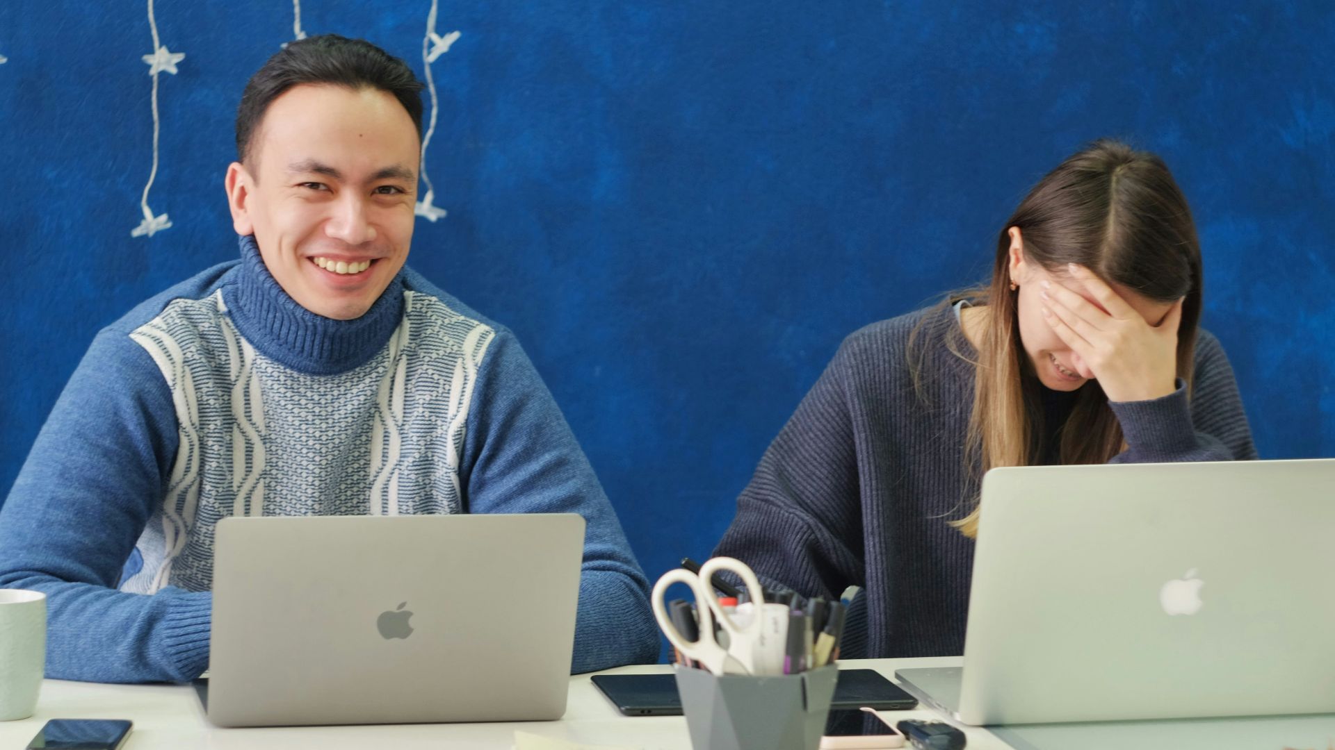 woman in gray sweater using silver macbook