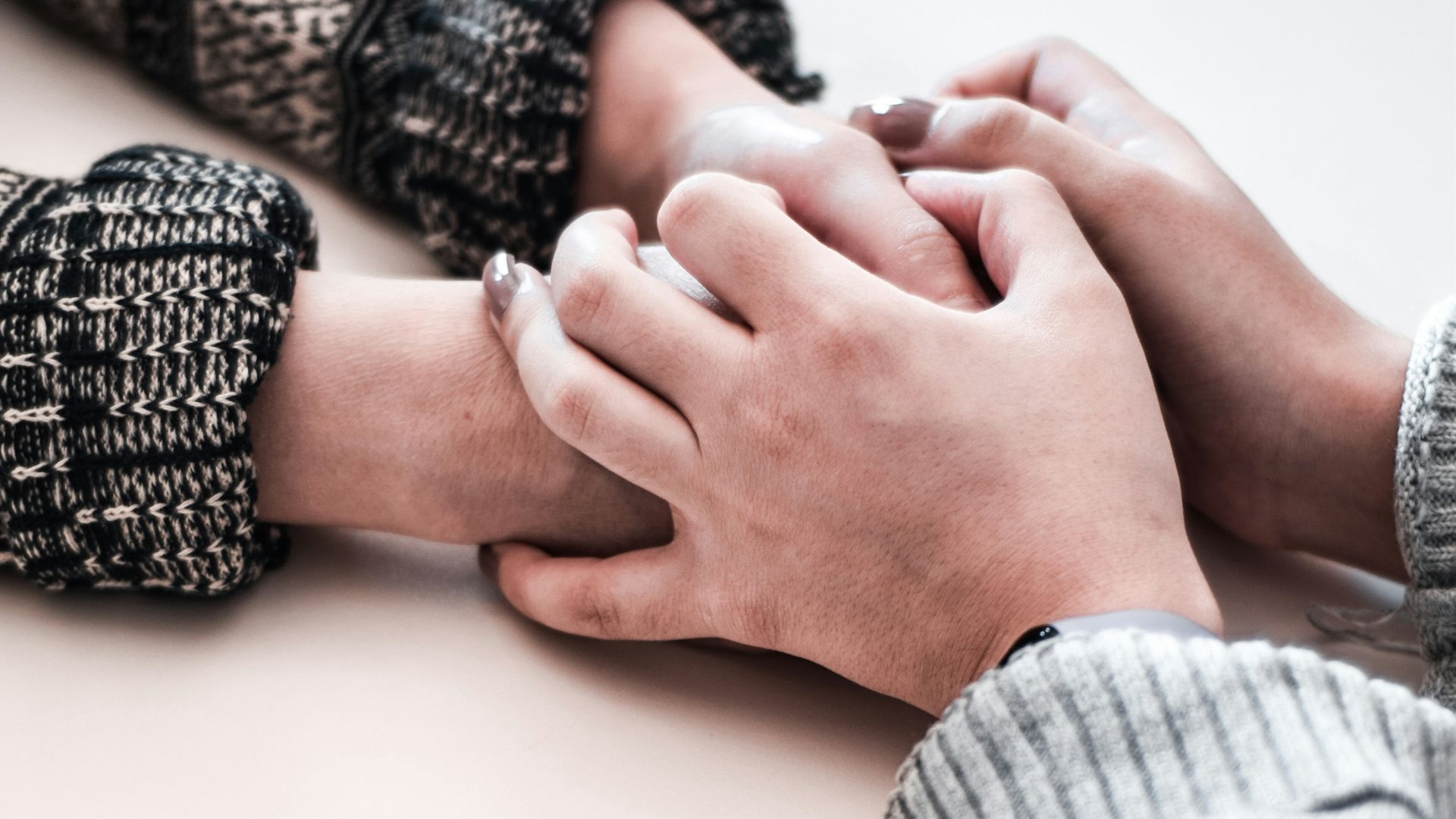 person in gray long sleeve shirt holding persons hand
