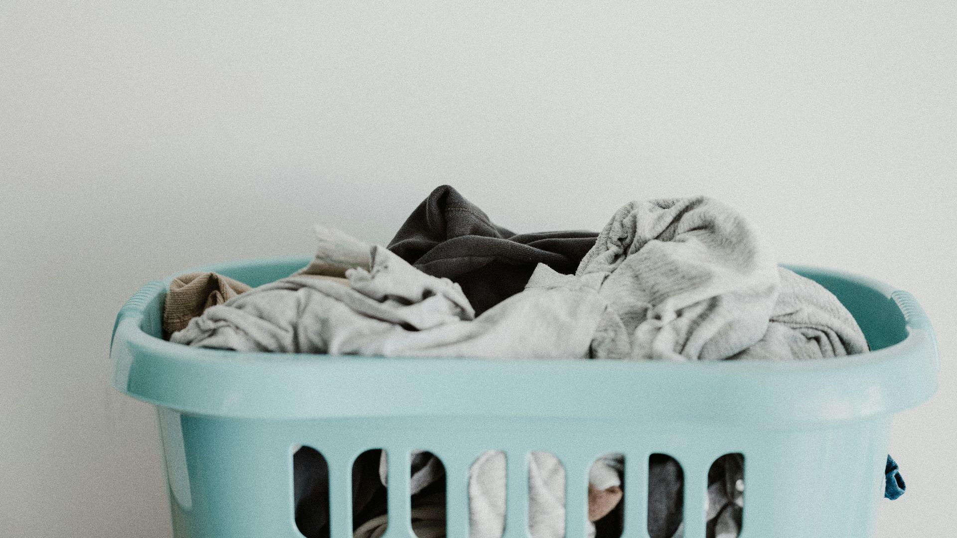 white textile on blue plastic laundry basket