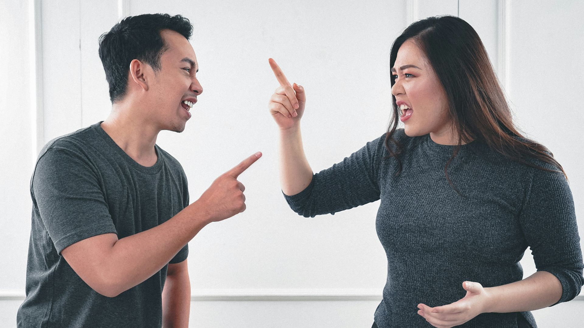 man in gray crew neck long sleeve shirt standing beside woman in black crew neck shirt