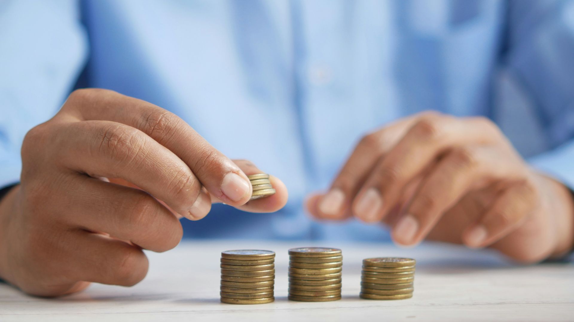 a person stacking coins on top of a table