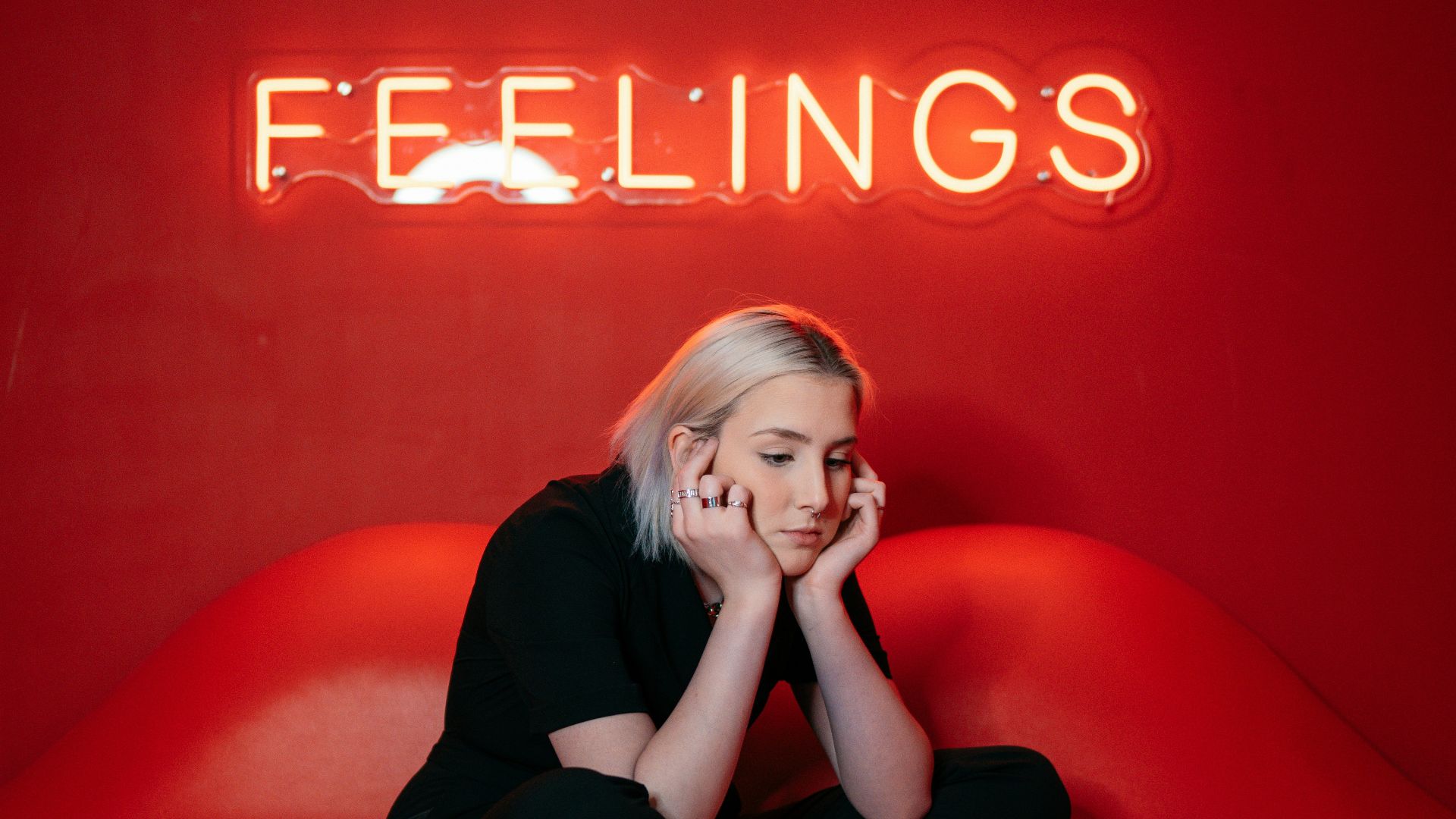 woman in black long sleeve shirt and black pants sitting on red couch