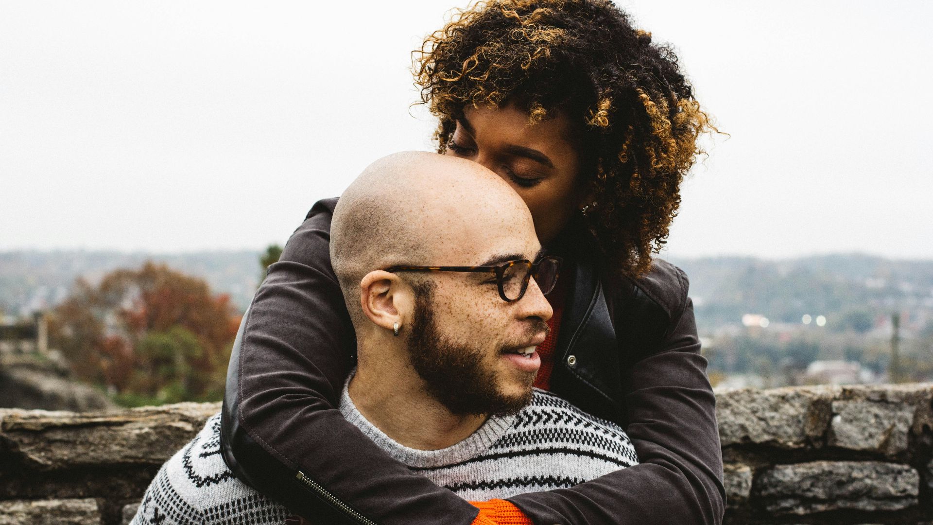 woman kissing man's head