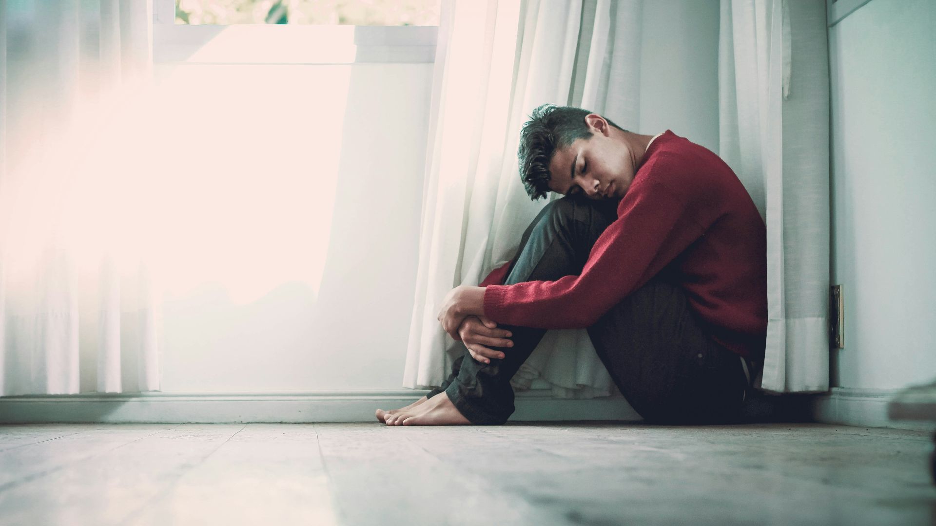 man beside white frame window