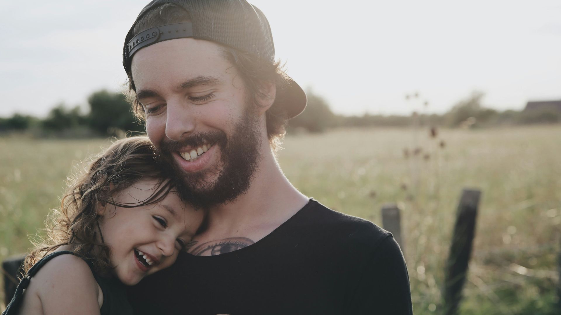 man carrying daughter in black sleeveless top