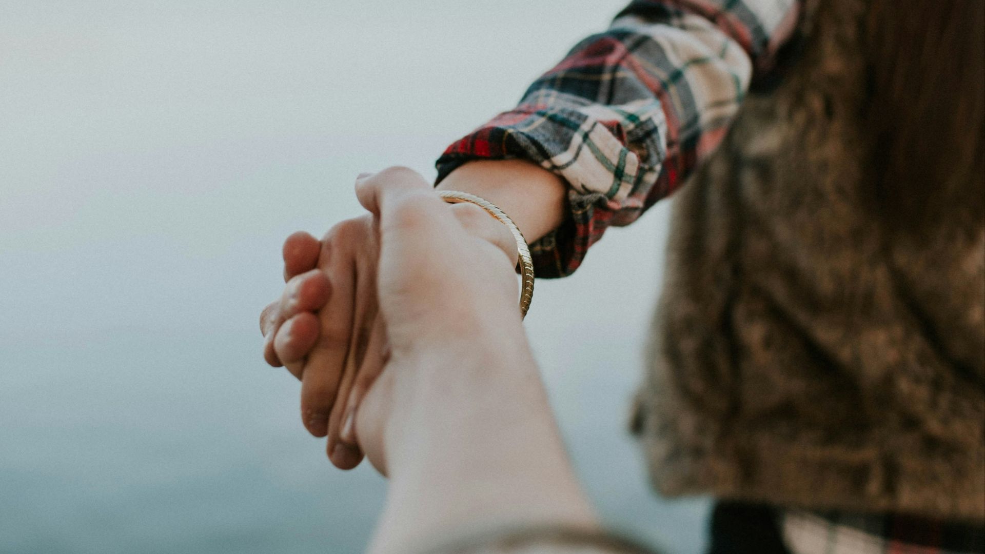 shallow focus photography of man and woman holding hands