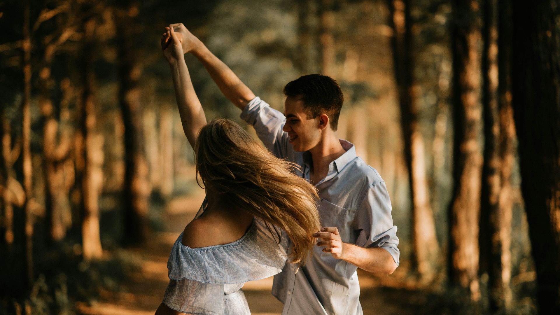 man and woman dancing at center of trees