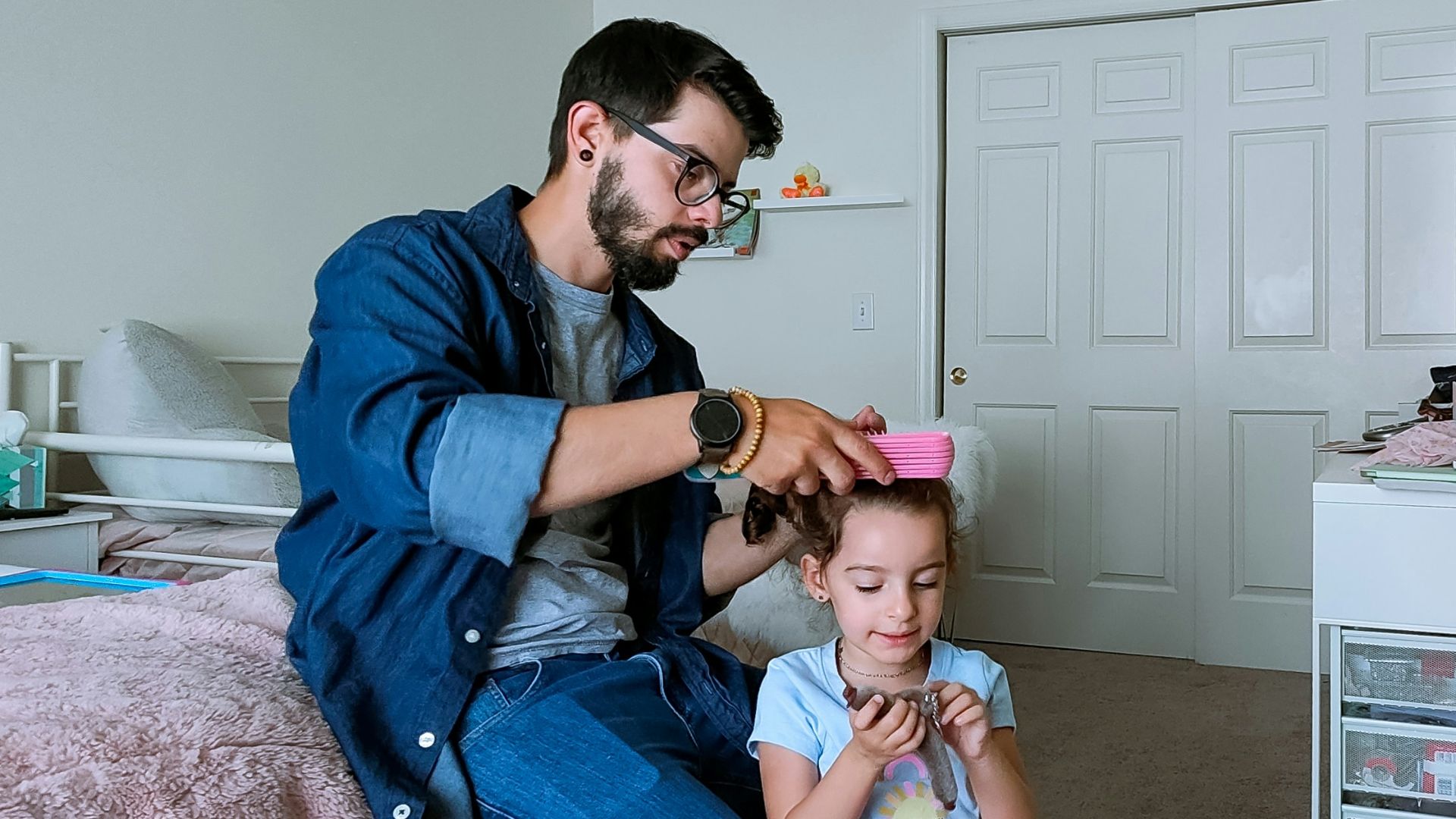a person and a child sitting on a bed