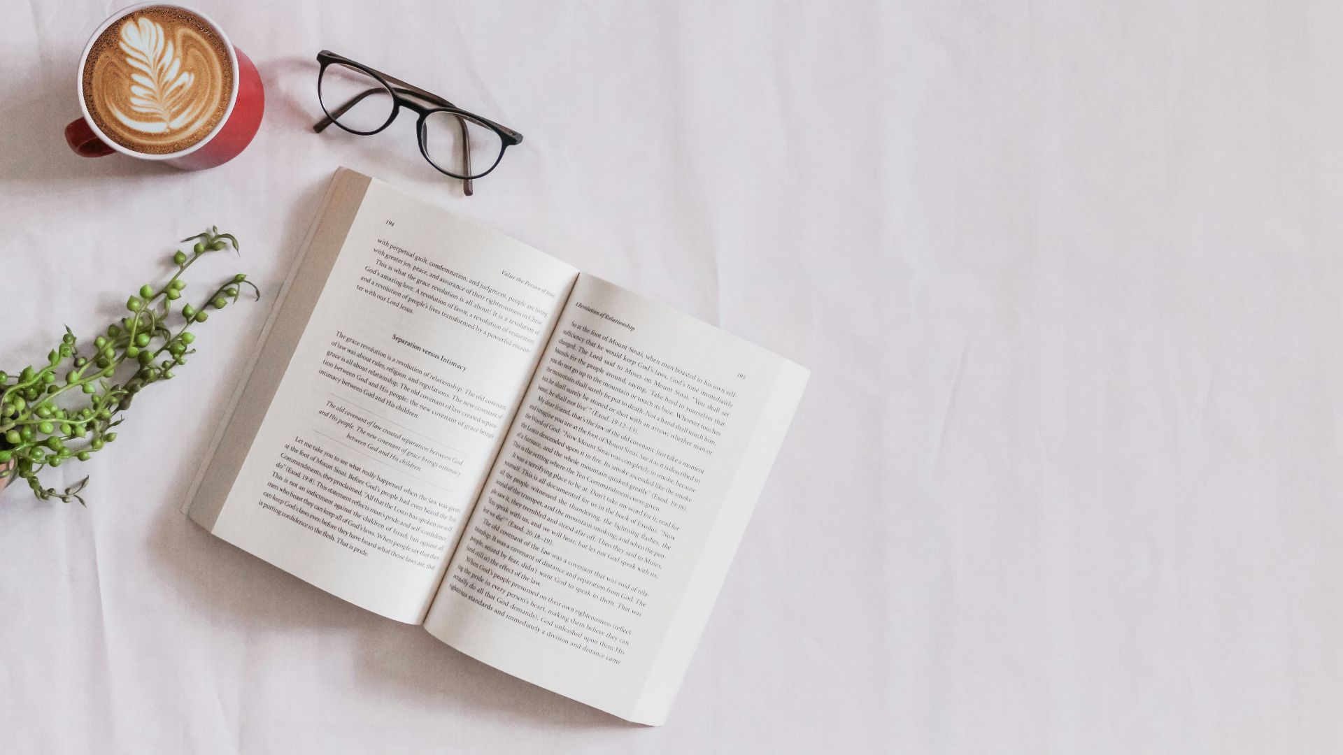 book page beside eyeglasses and coffee