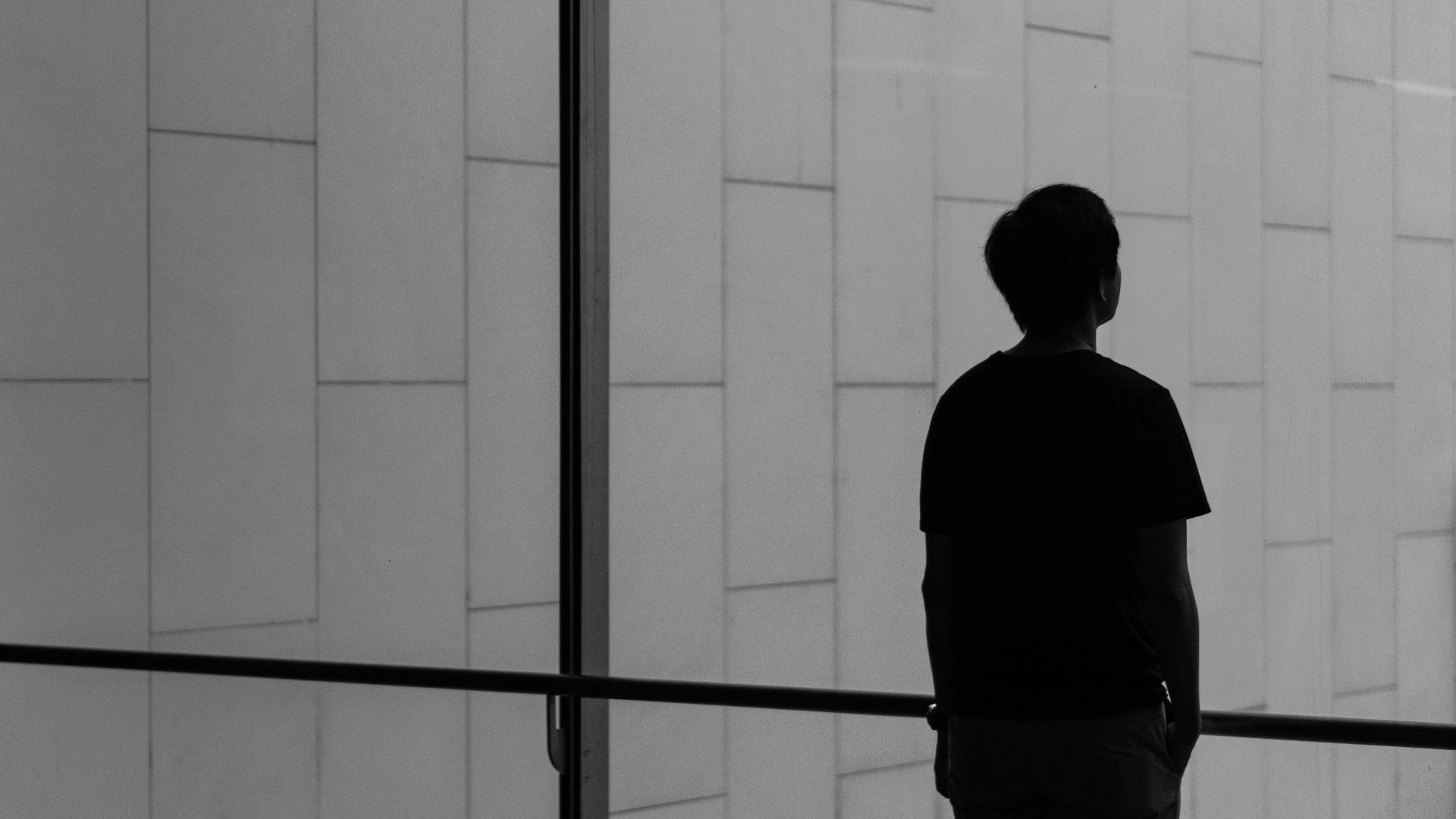 silhouette of a person facing glass wall