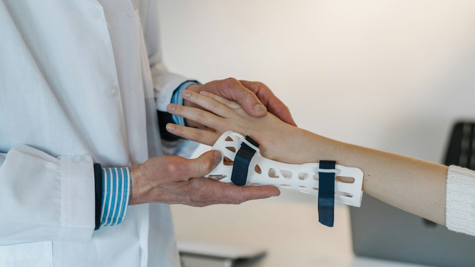 person in white coat holding silver and blue ring