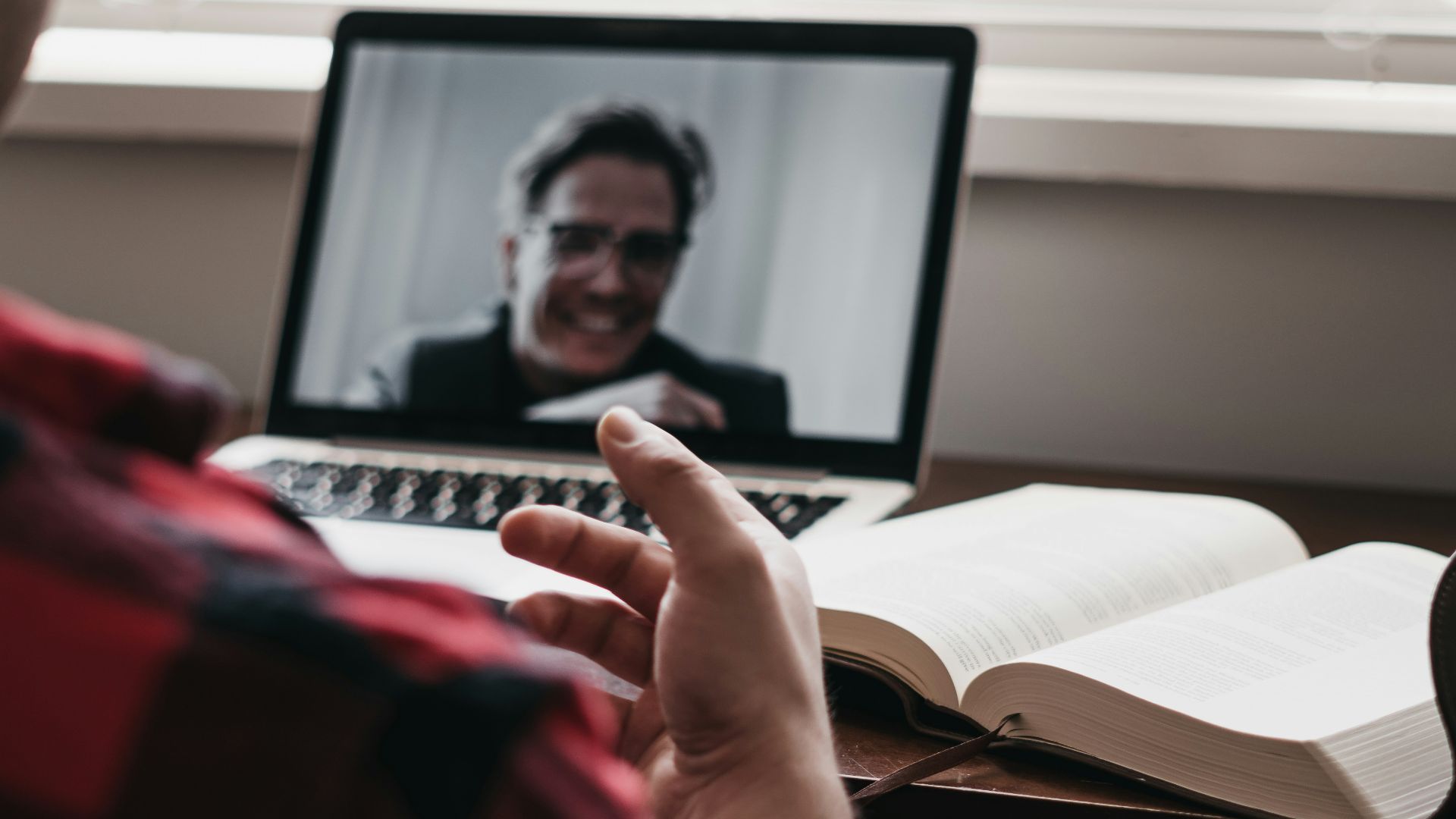 person in red and black plaid long sleeve shirt using black laptop computer