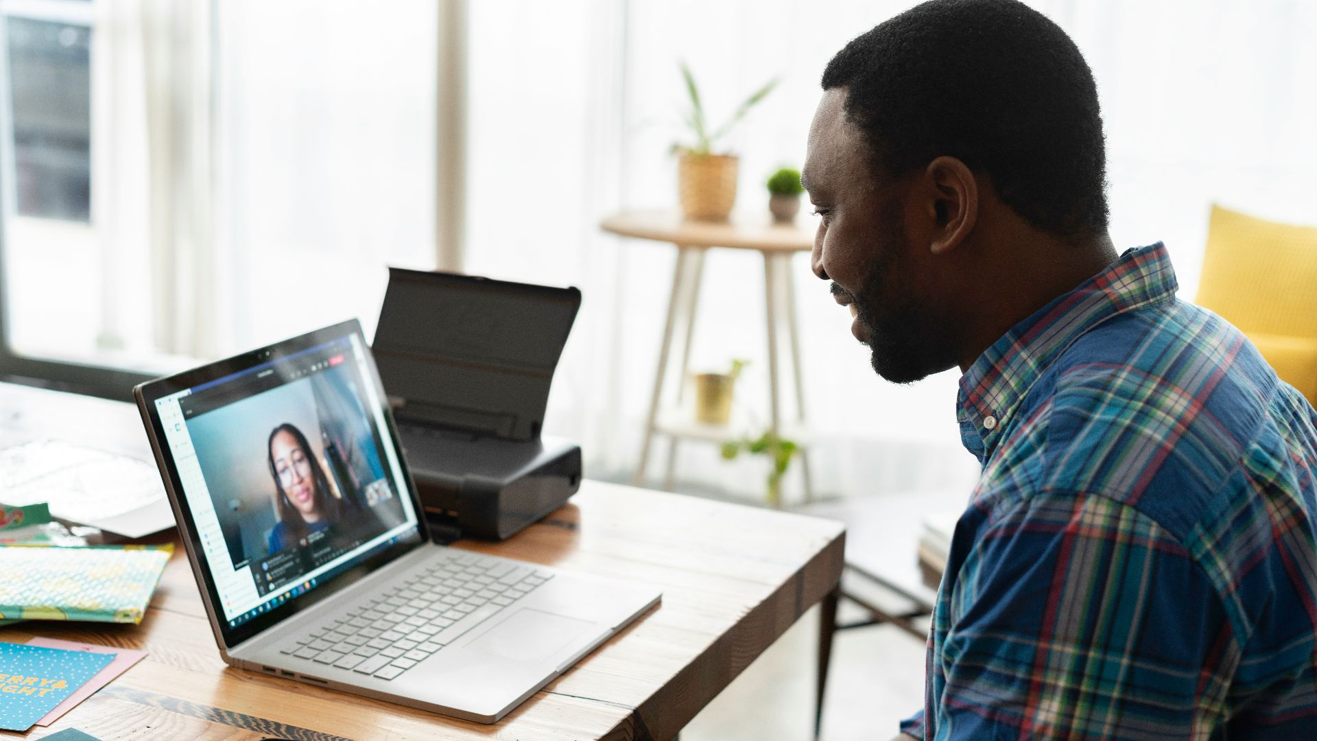 man in blue and white plaid dress shirt using macbook pro