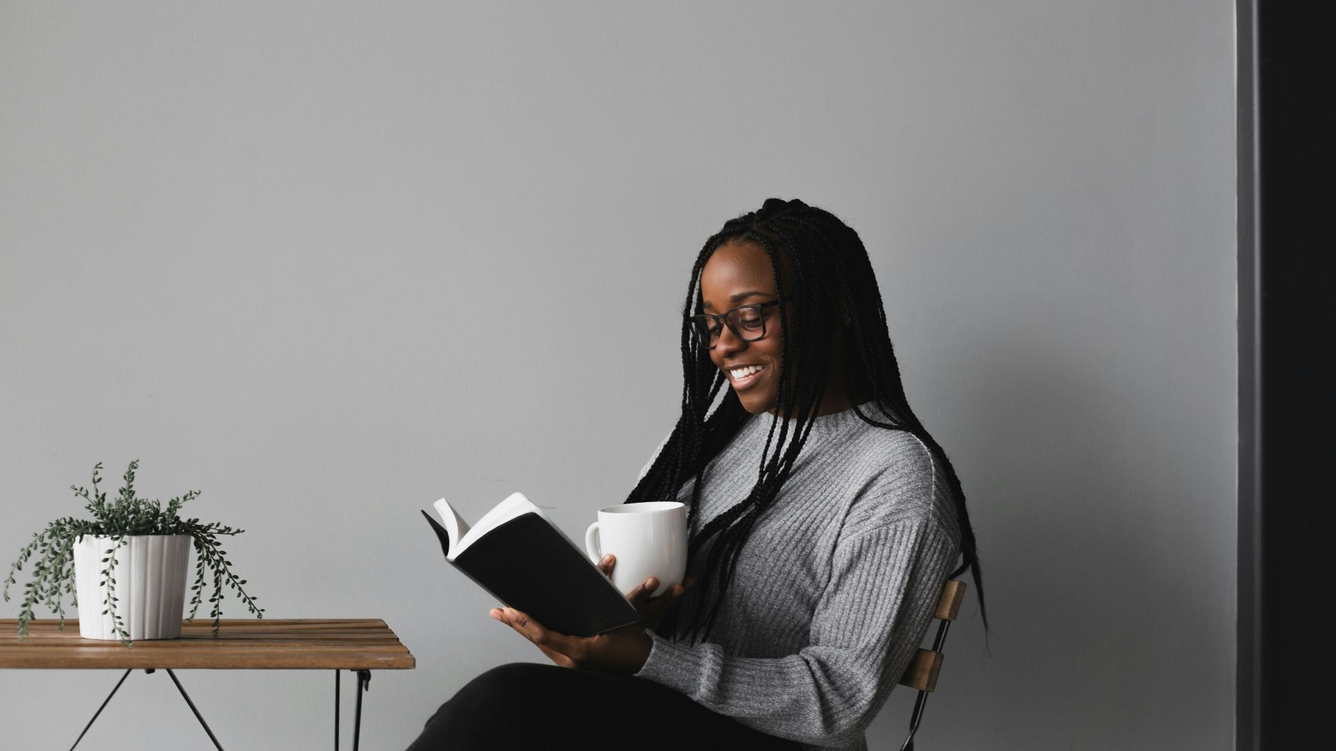 woman in white and black stripe long sleeve shirt sitting on chair