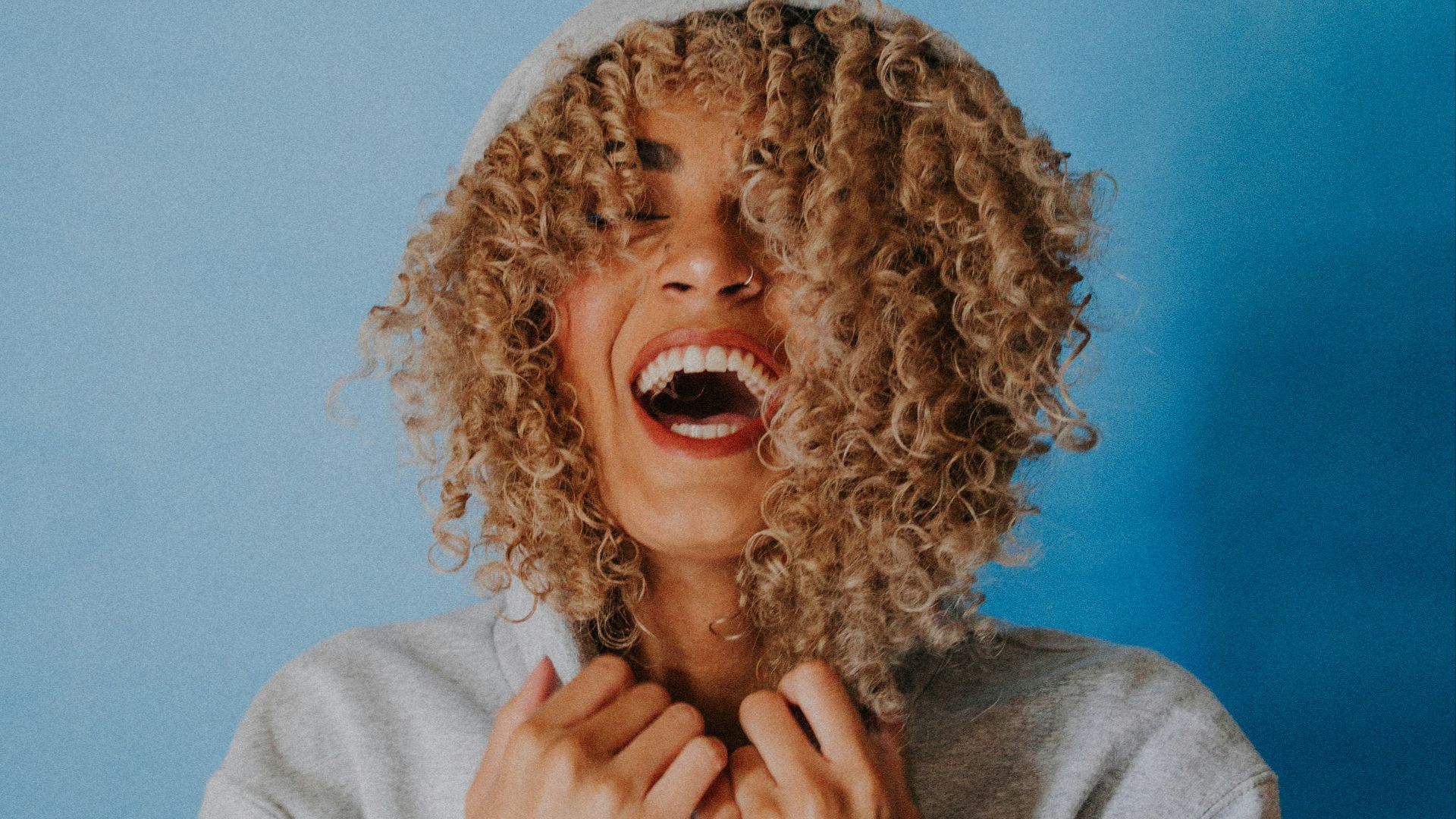 smiling woman wearing gray hoodie