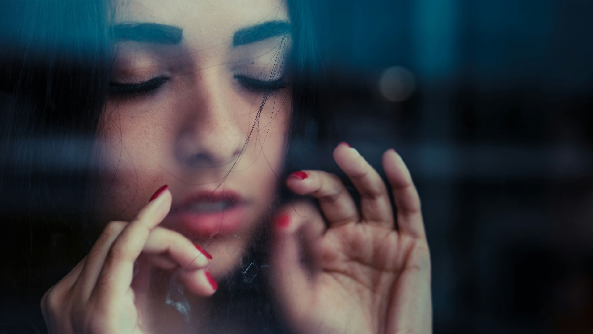 woman showing both hands with red manicures