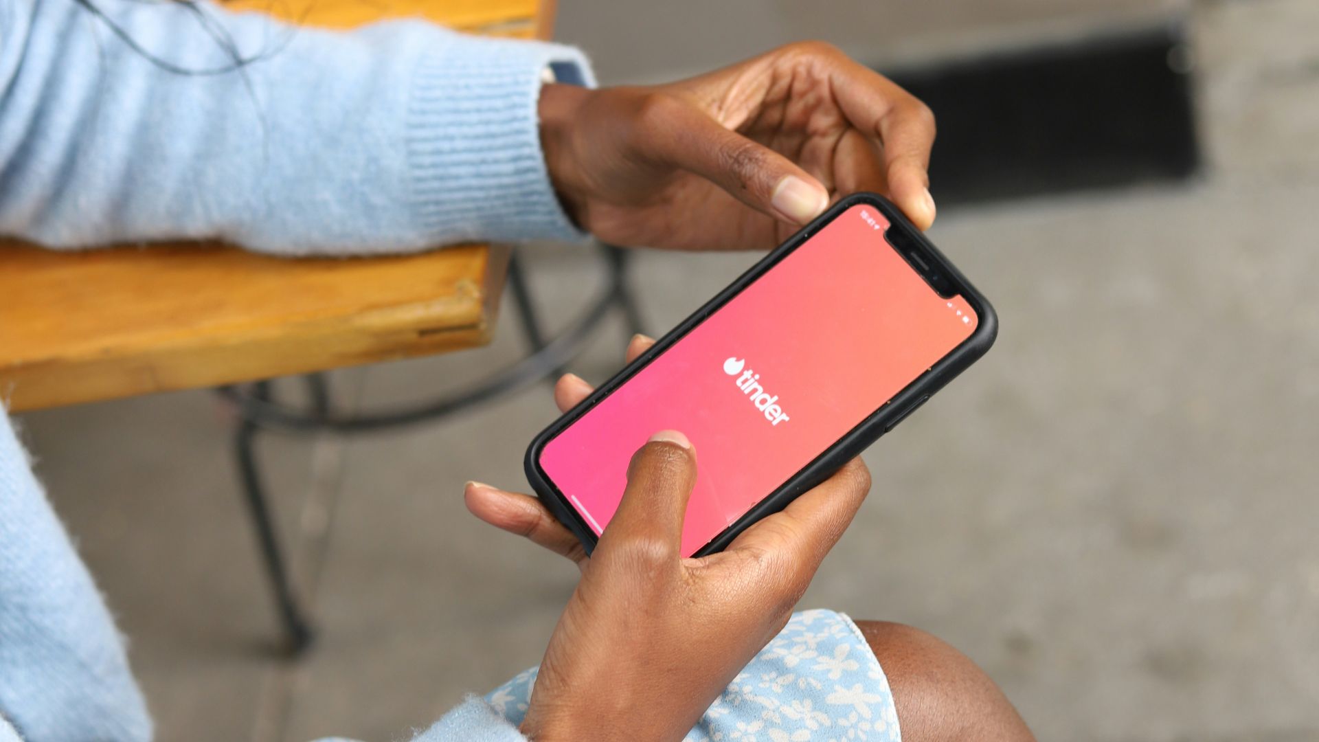 a woman sitting on a bench holding a cell phone