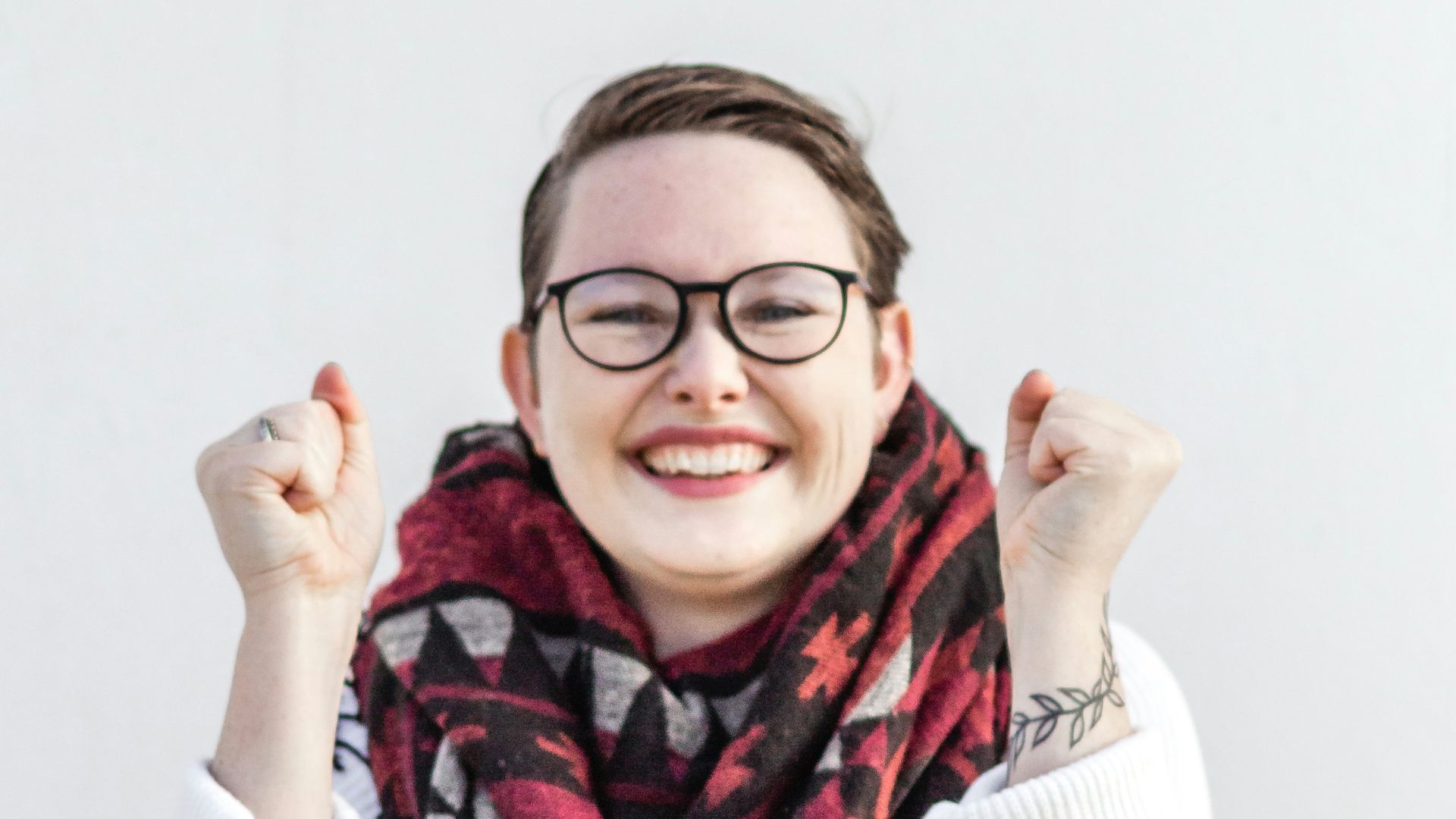 woman in white sweater wearing red scarf and black framed eyeglasses