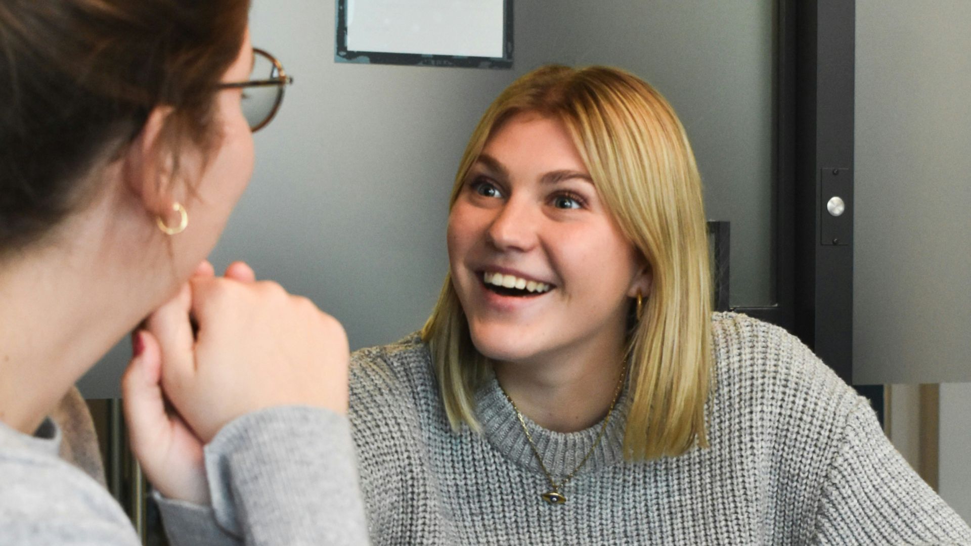 woman in gray sweater sitting beside woman in gray sweater