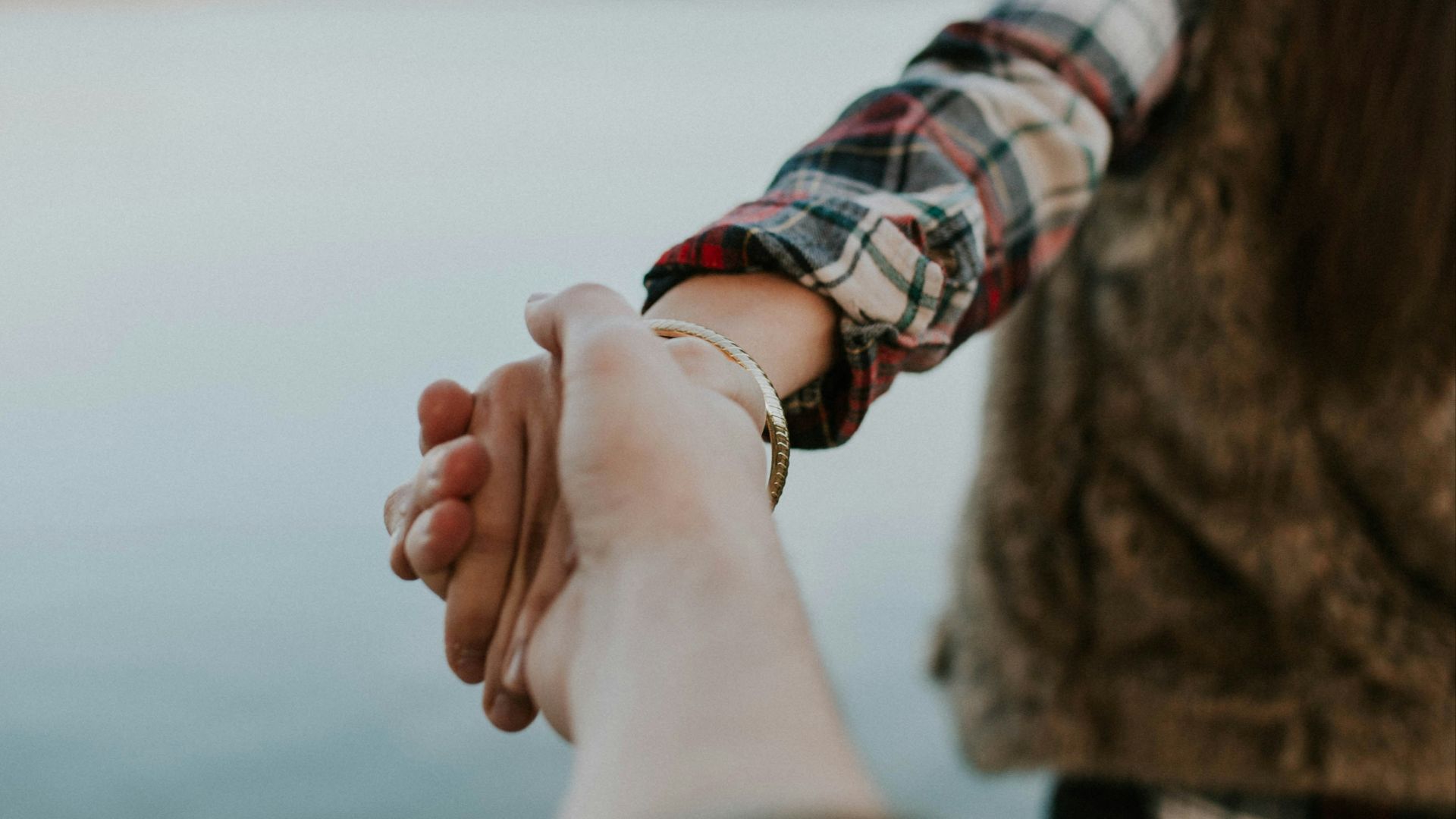 shallow focus photography of man and woman holding hands