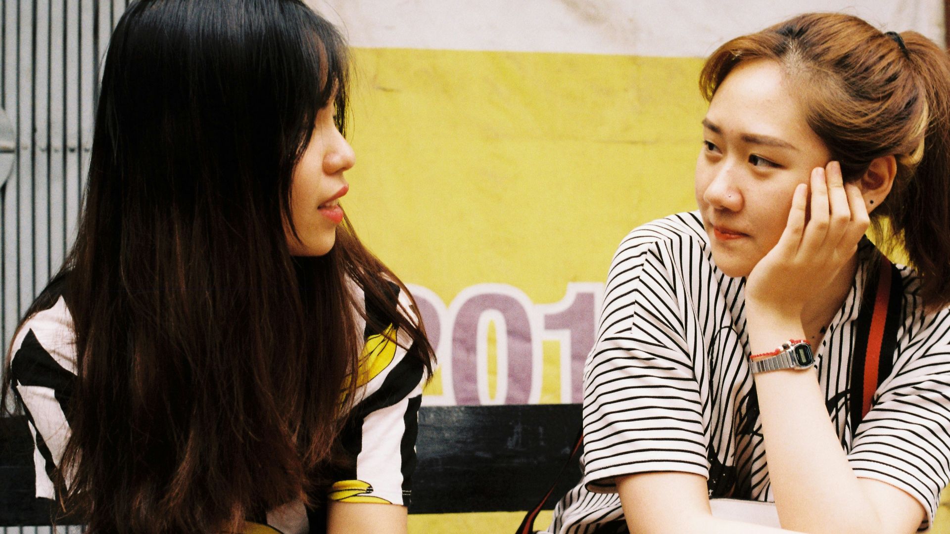 woman in white-and-black striped tops looking each other