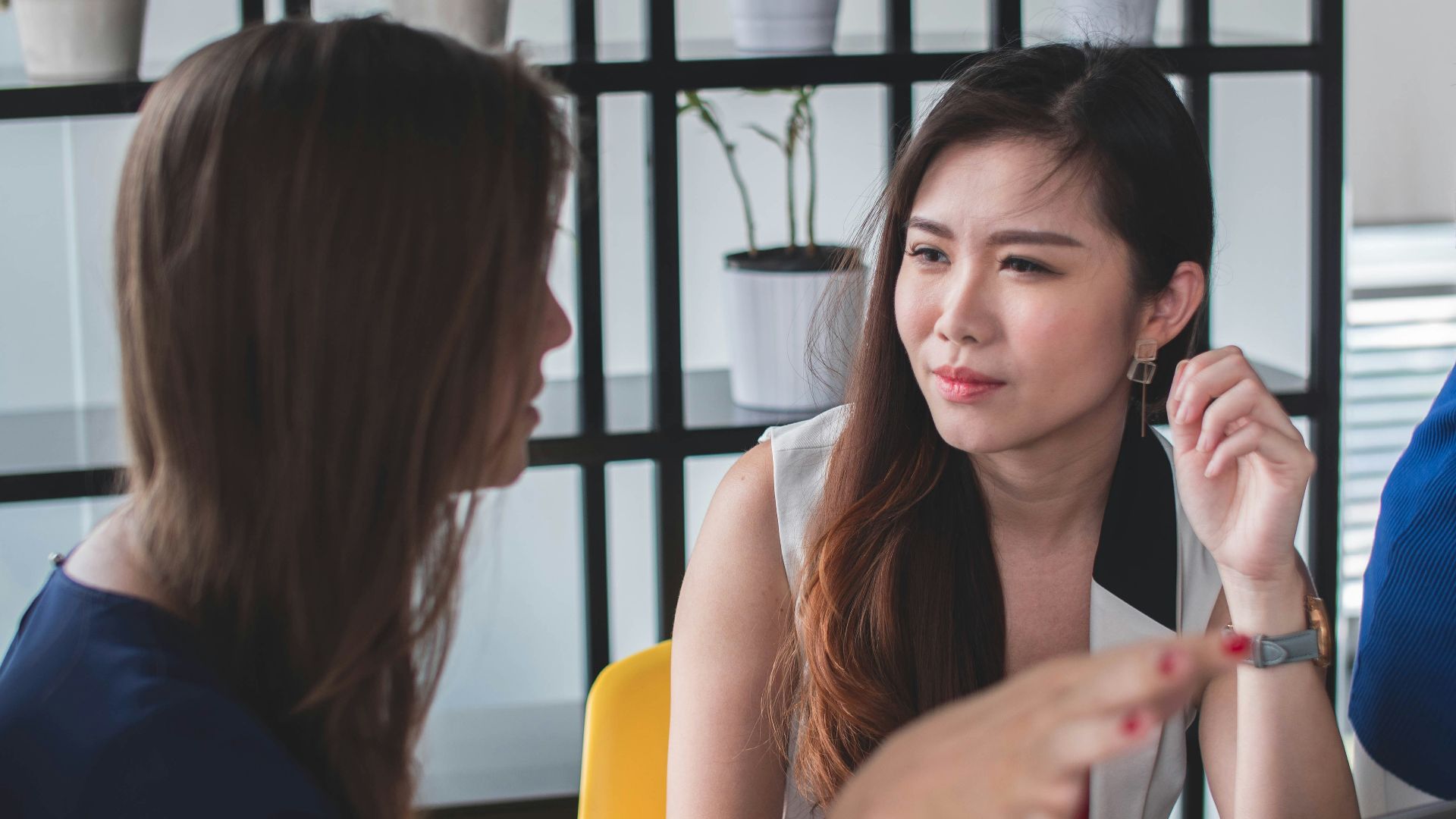 woman sitting on yellow armless chair near gray laptop computer