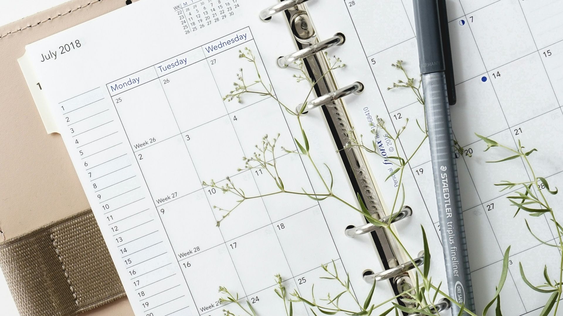 grey and black pen on calendar book