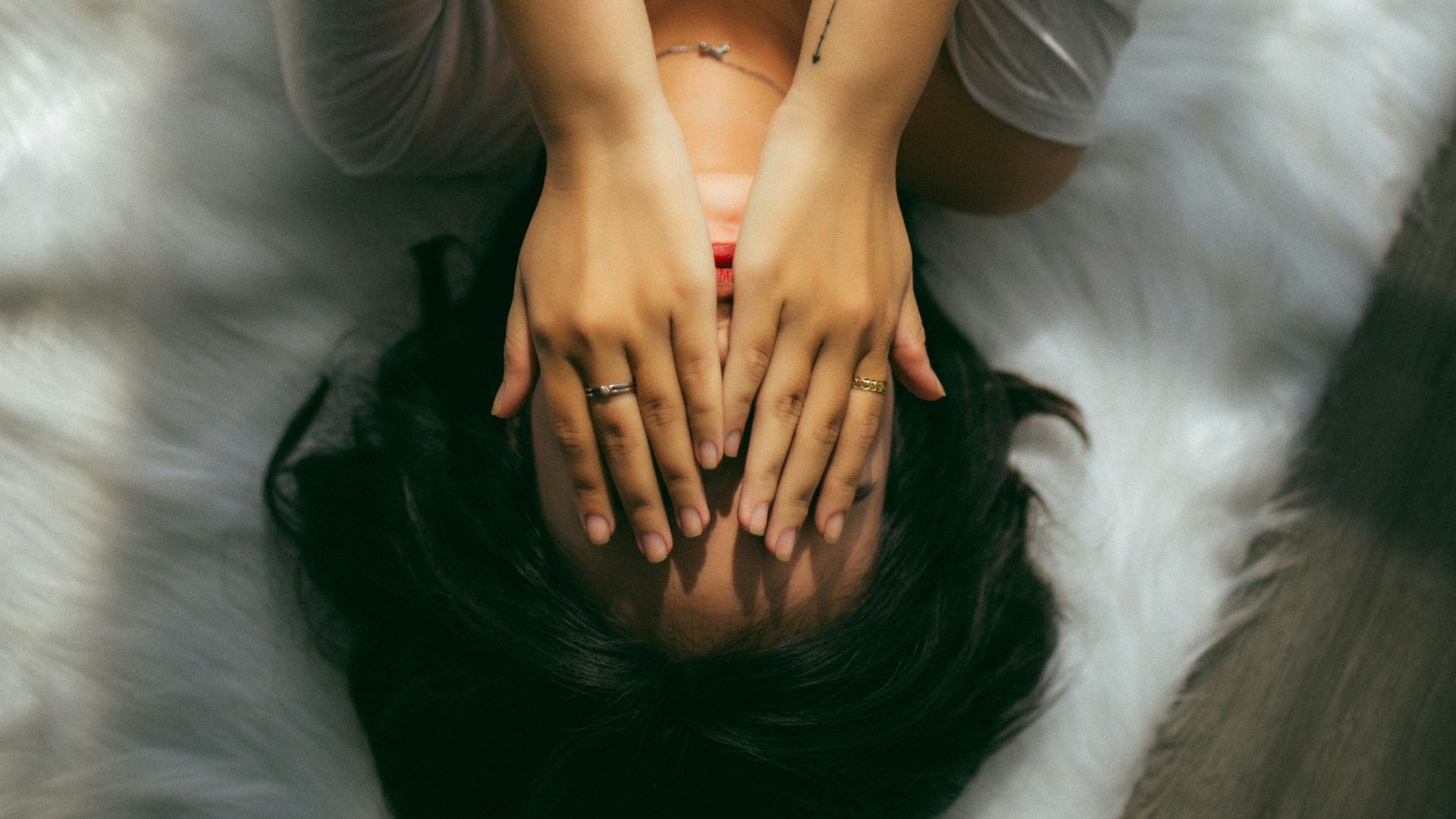 a woman holds her hands over her face