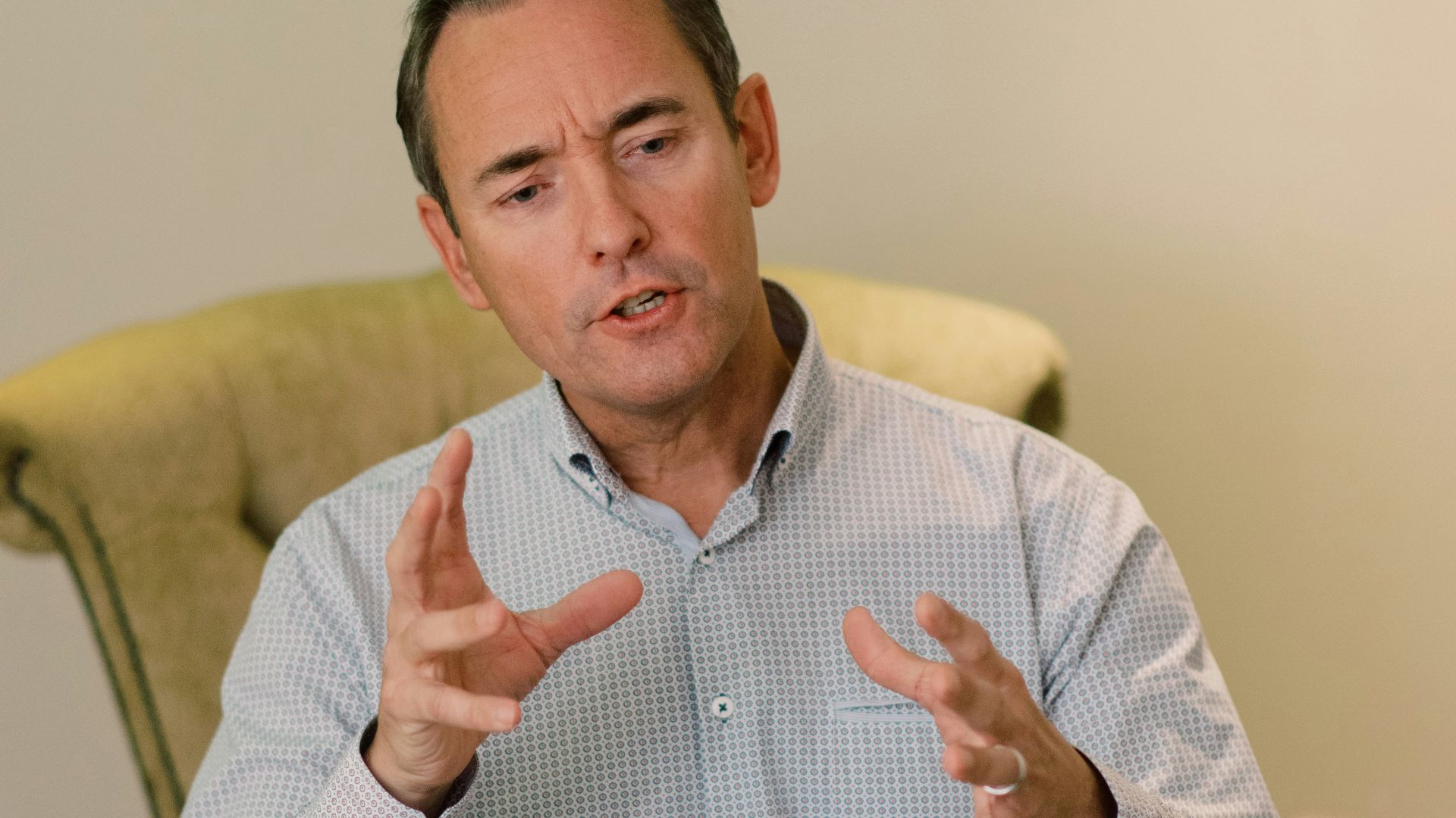 man in blue dress shirt sitting on yellow chair