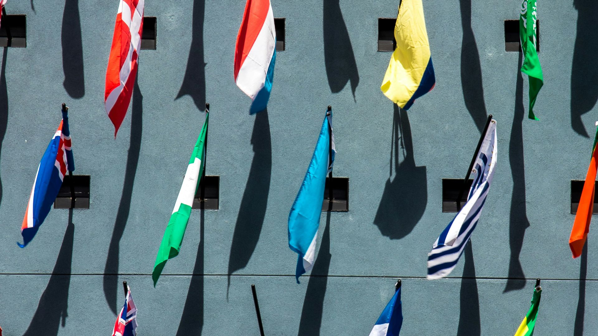 photo of assorted-color nation flags on wall during daytime