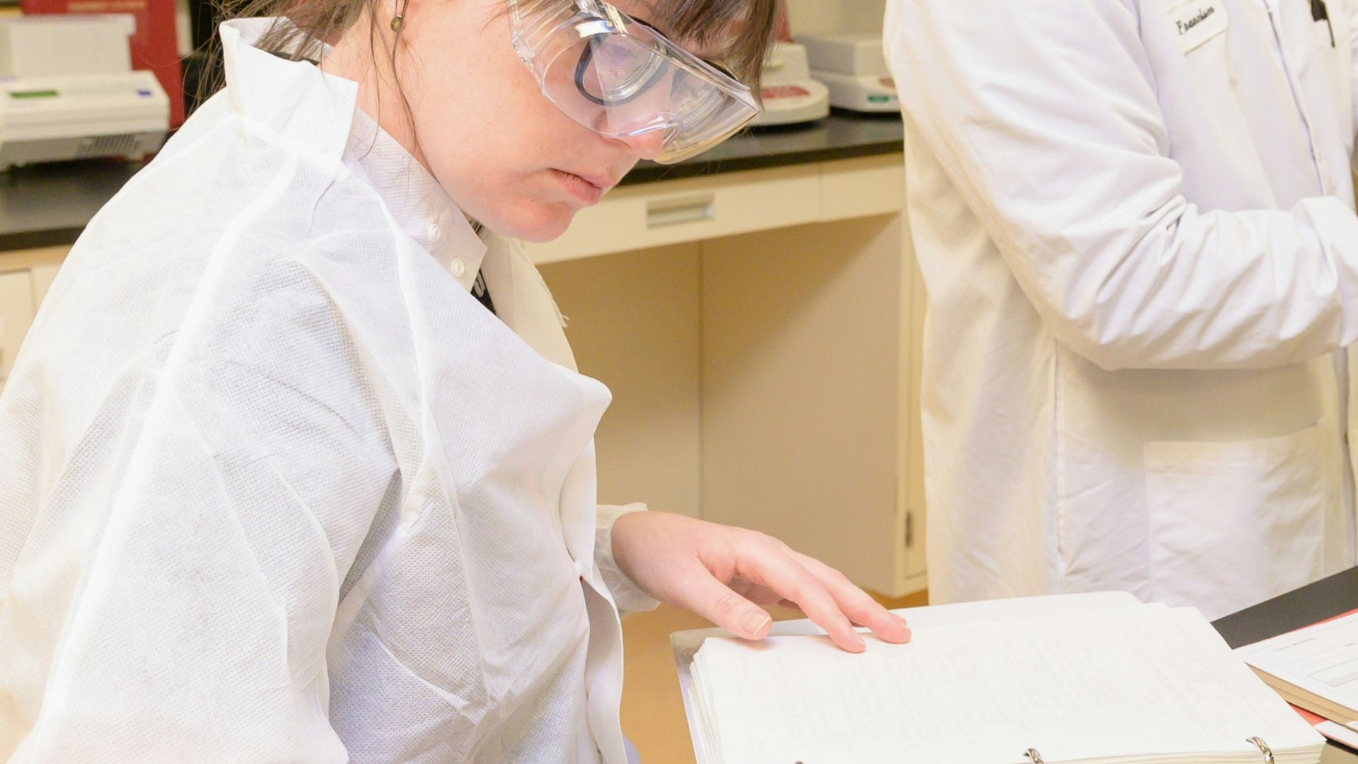 a group of people in lab coats working in a lab