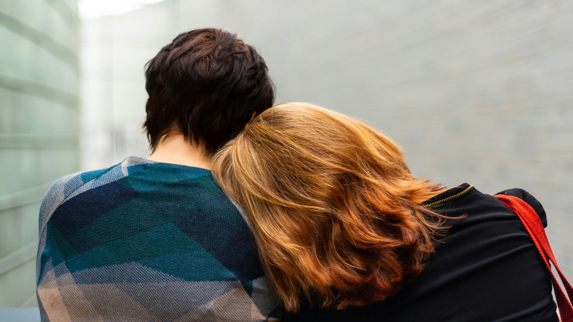 a woman rests her head on another person's shoulder